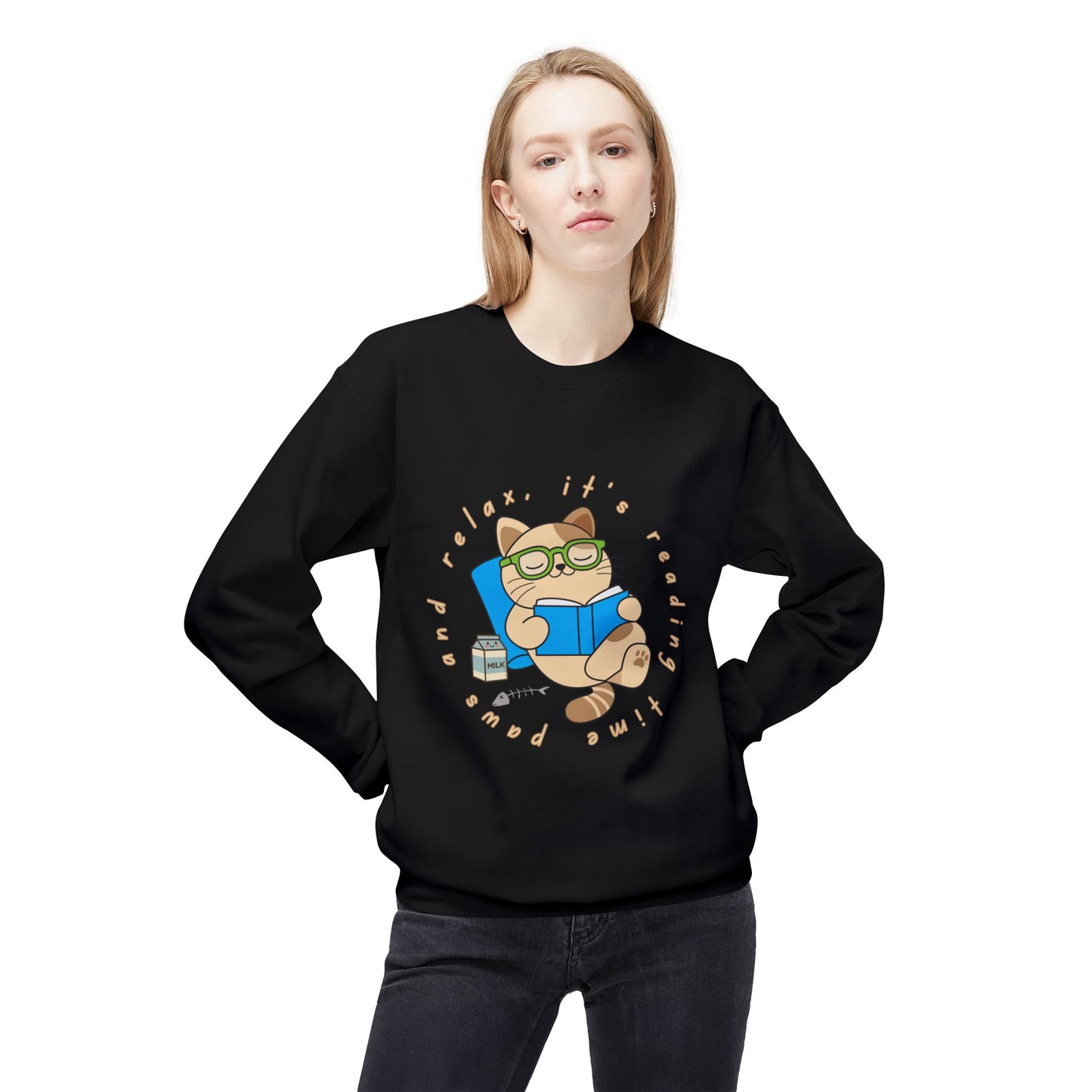 Woman wearing a black sweatshirt with a cat reading a book graphic and text 'Paws and relax, it's reading time'
