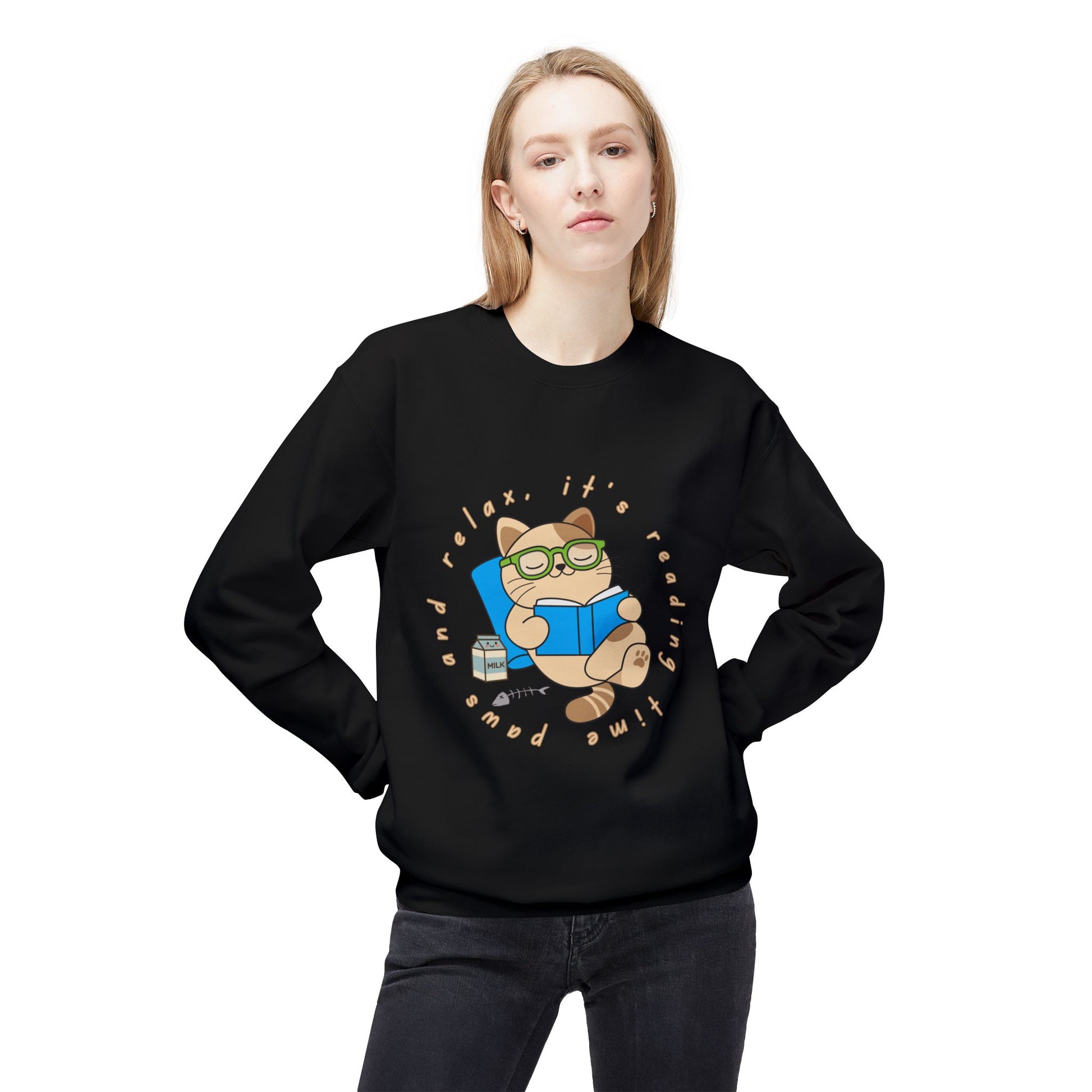 Woman wearing a black sweatshirt with a cat reading a book graphic and text 'Paws and relax, it's reading time'