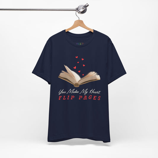Navy blue t-shirt with a graphic of an open book with hearts floating from the pages and text 'You Make My Heart FLIP PAGES' 