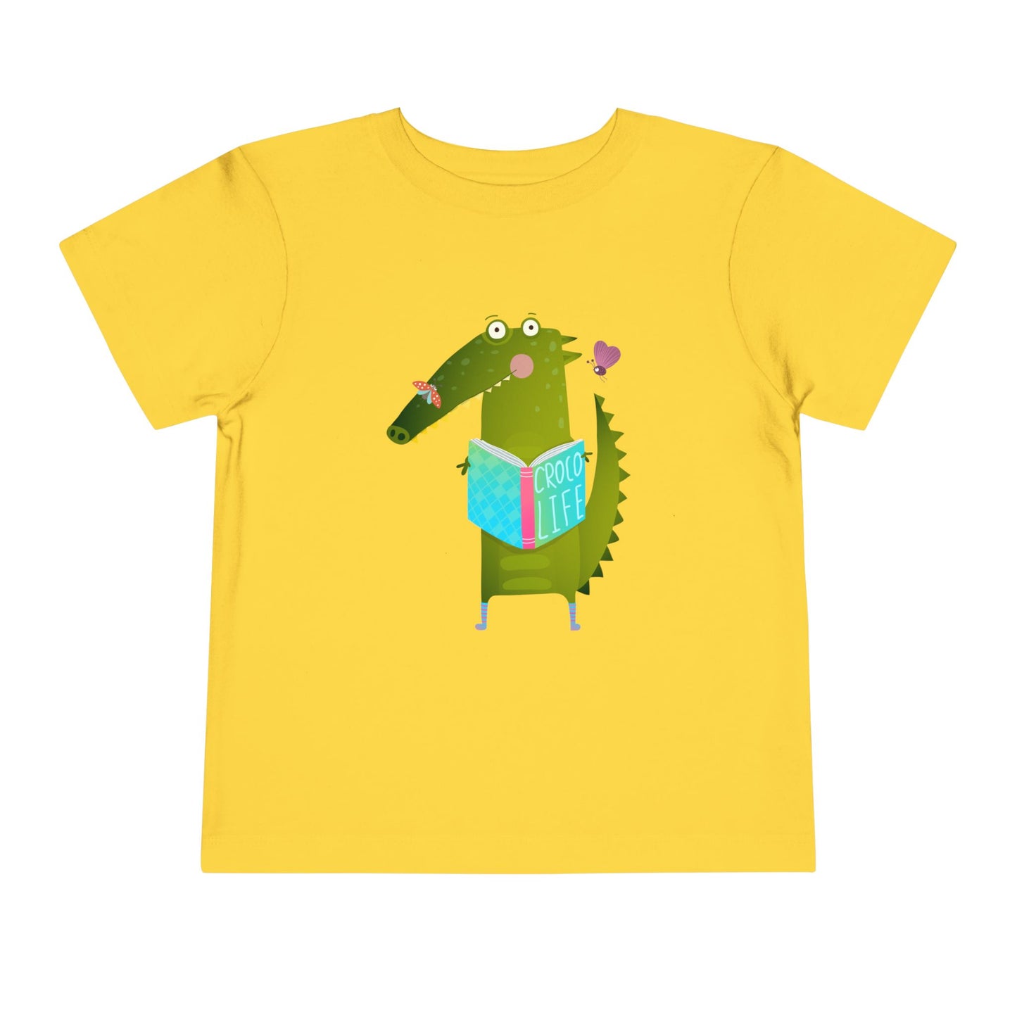Yellow t-shirt with a cartoon crocodile reading a Croc Life book amongst sweet insects 