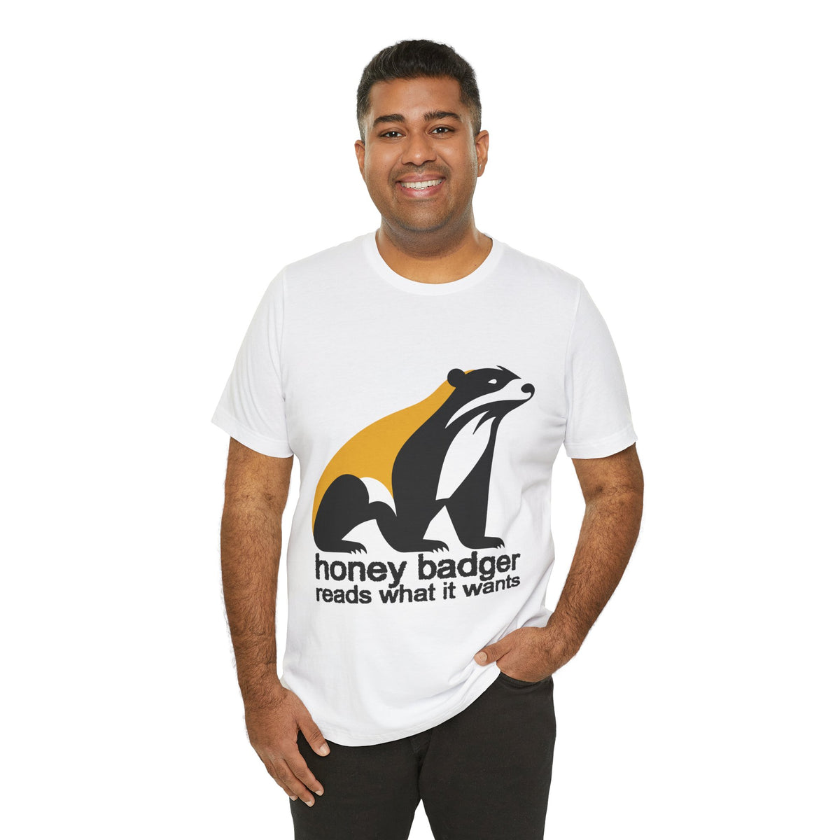 Man wearing a white t-shirt featuring a large black yellow and white badger with text "honey badger reads what it wants"