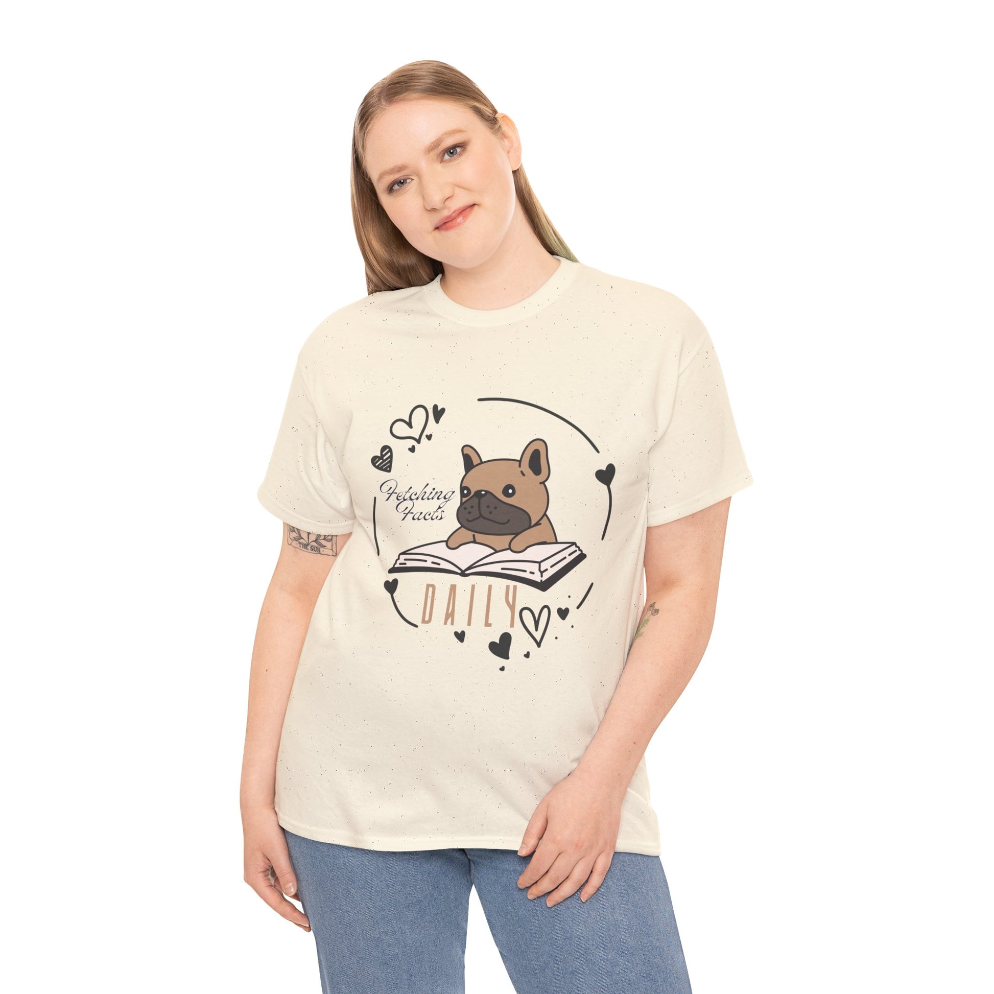 Woman weing a beige t-shirt with a dog graphic reading a book and text 'Fetching Facts Daily, circled with hearts 