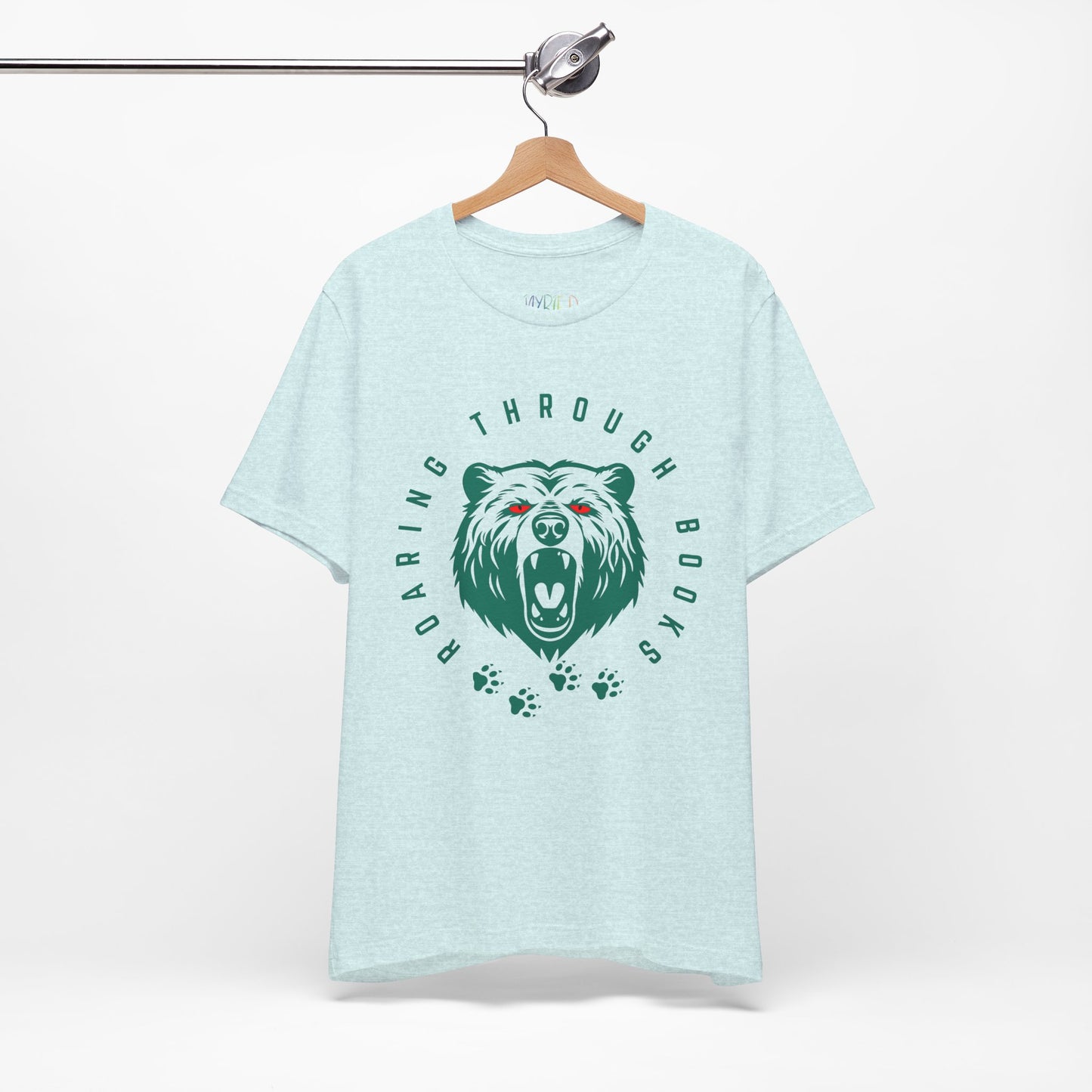 Light ice blue t-shirt with a green bear graphic, red eyes and circular text 'Roaring Through Books'
