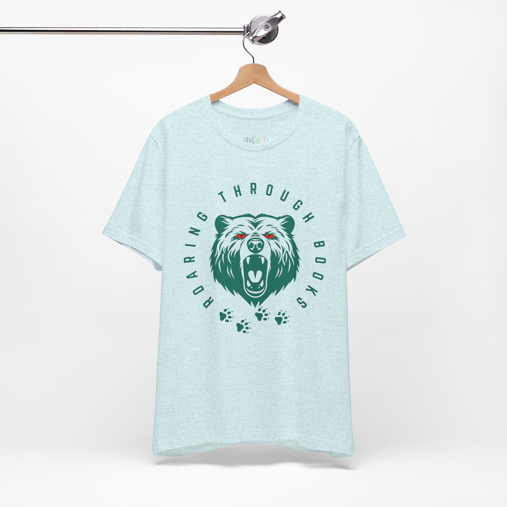 Light ice blue t-shirt with a green bear graphic, red eyes and circular text 'Roaring Through Books'