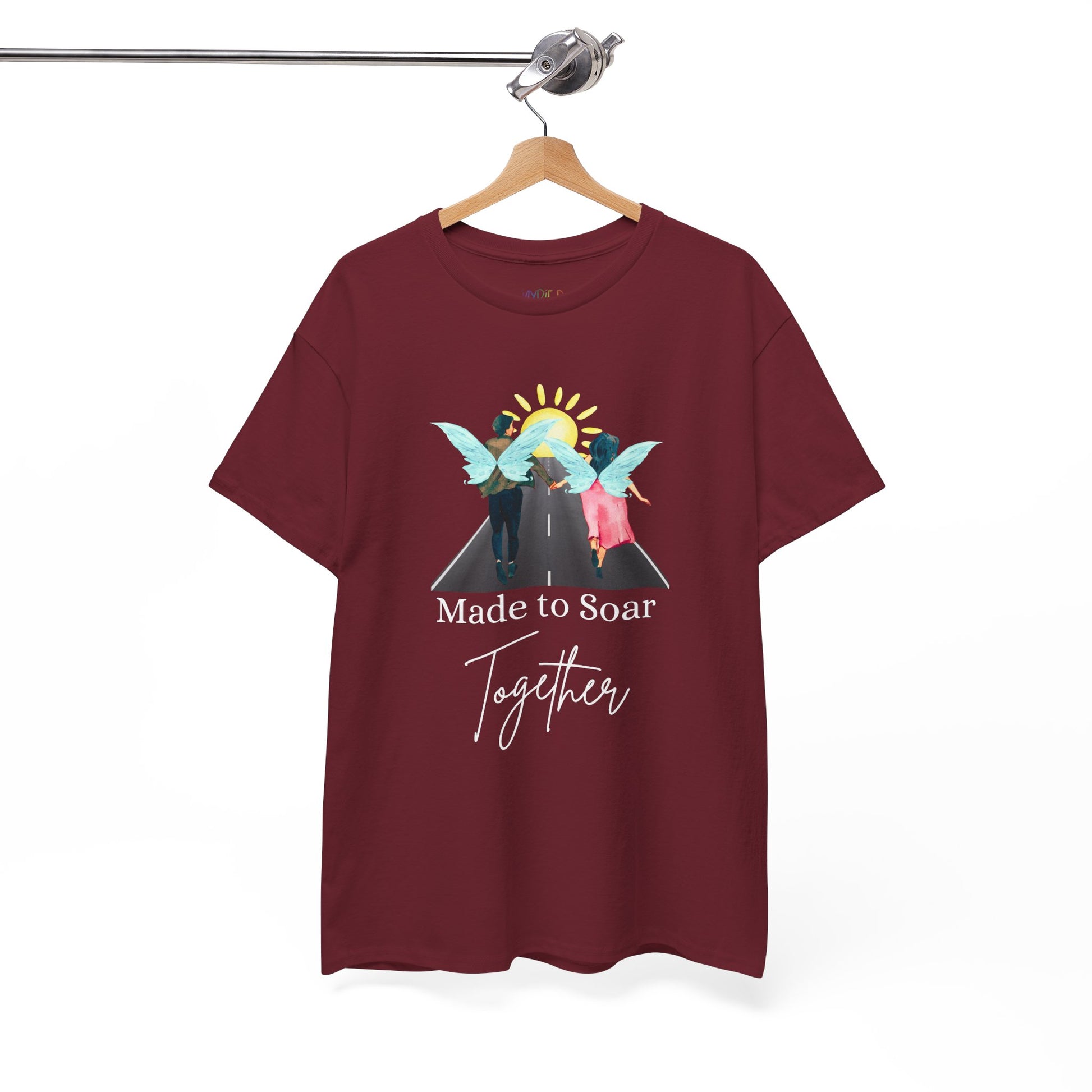 Maroon t-shirt with graphic design of two fairies running down the toward toward the sunset and text 'Made To Soar Together' and text 'Made to Soar Together' 