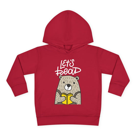 Illustration of a bear holding a yellow book with the words “Let’s Read” above — printed on a dark toddler hoodie.