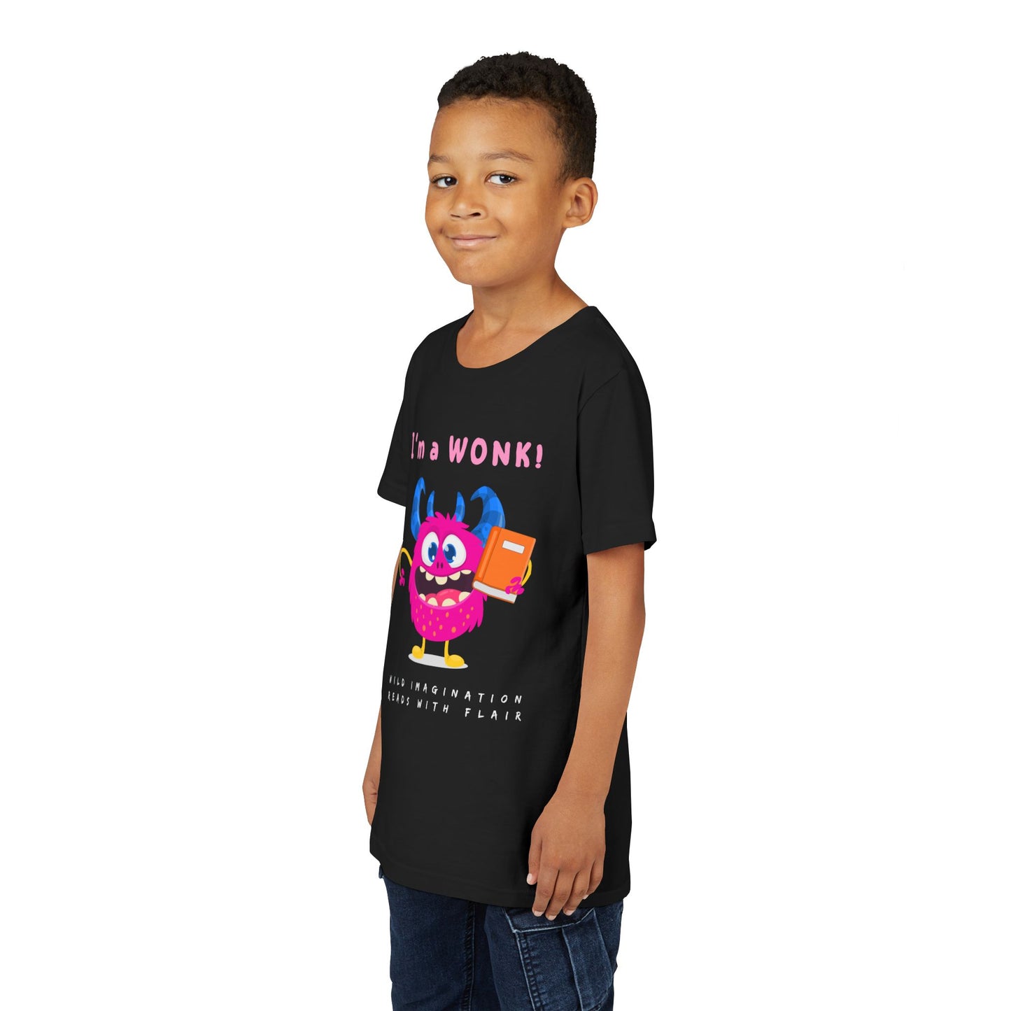 Boy wearing a black personality t-shirt with a colorful pink monster graphic holding a book and proudly stating 'I'm a WONK!'