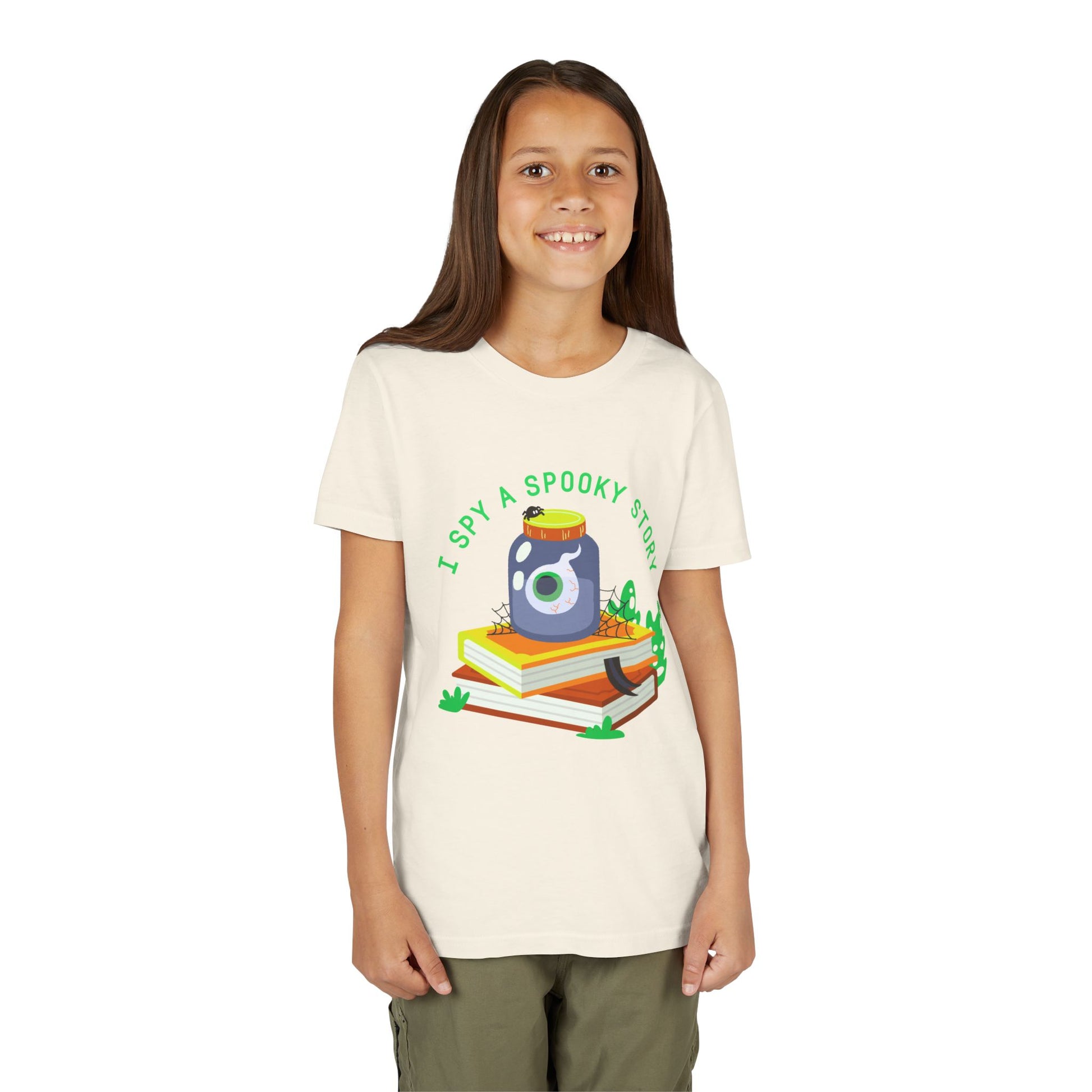 Girl wearing a beige t-shirt with a graphic design of a jar with an eyeball, books, a spider and text 'I Spy A Spooky Story'