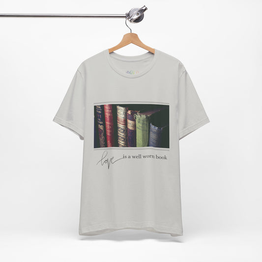 Gray t-shirt with a row of old books and text 'Love Is A Well Worn Book'