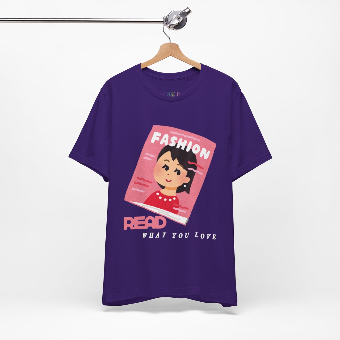 Purple t-shirt with a graphic design of a girl on a fashion magazine and text 'Read What You Love' 