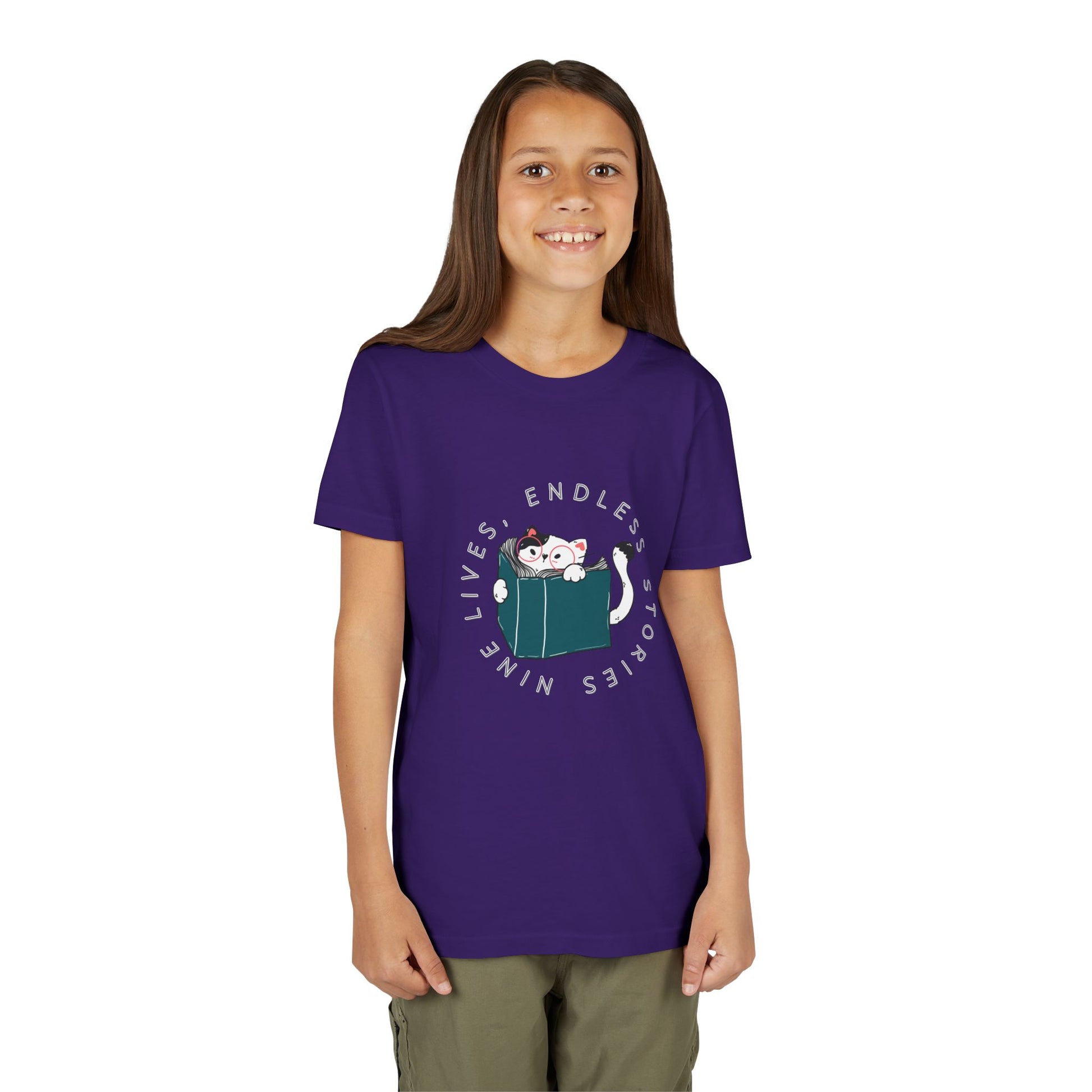 Girl wearing a purple t-shirt with a cat reading a book graphic and text 'nine lives, endless stories'