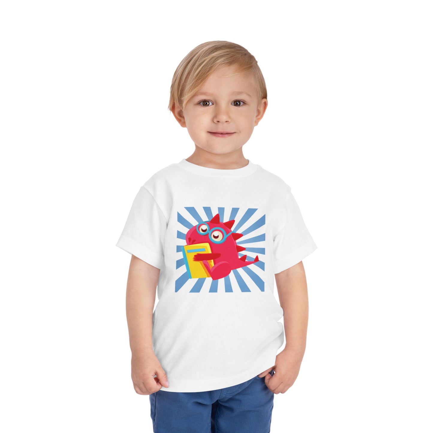 Toddler wearing a white t-shirt with a colorful cartoon dragon hugging a book and a blue energy burst background 