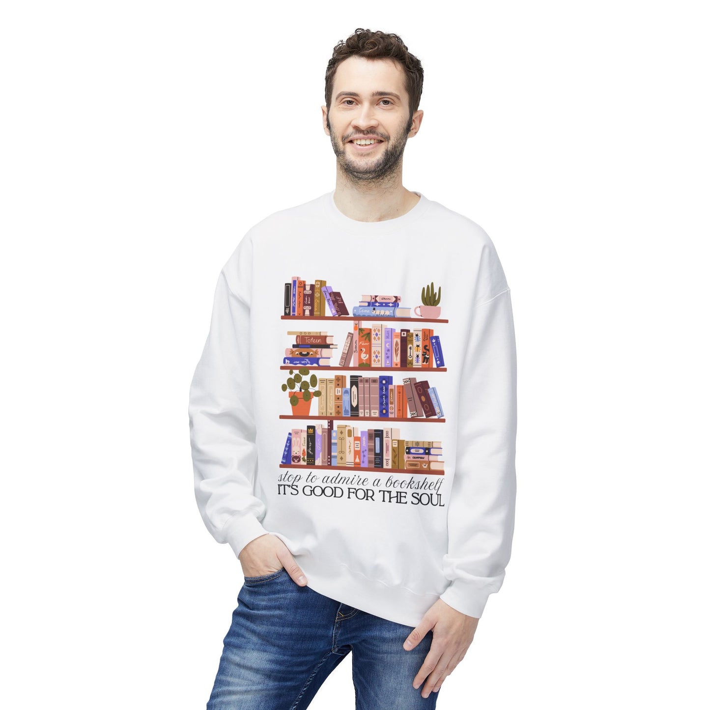 Man wearing a white sweatshirt with bookshelf design and text 'Stop to admire a bookshelf, it's good for the soul'