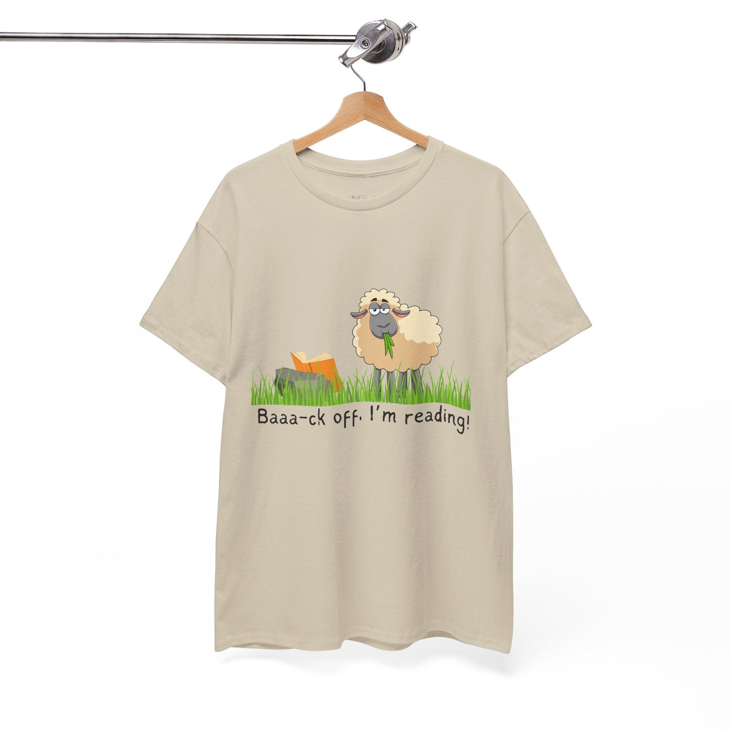 Tan t-shirt with a sheep munching grass and reading a book propped up on a rock, text 'Baaa-ck off. I'm Reading!'