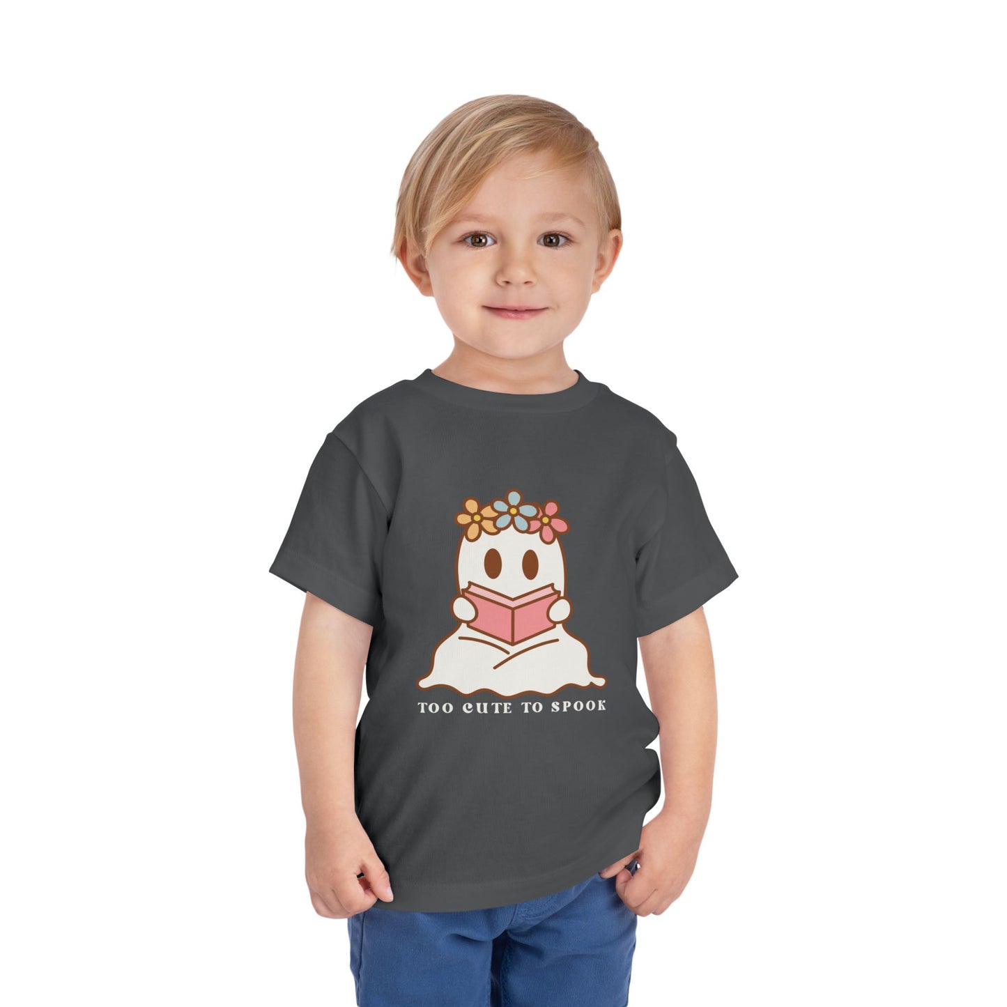 Child wearing a gray toddler t-shirt with a ghost reading a book and 'Too Cute to Spook' text on a white background