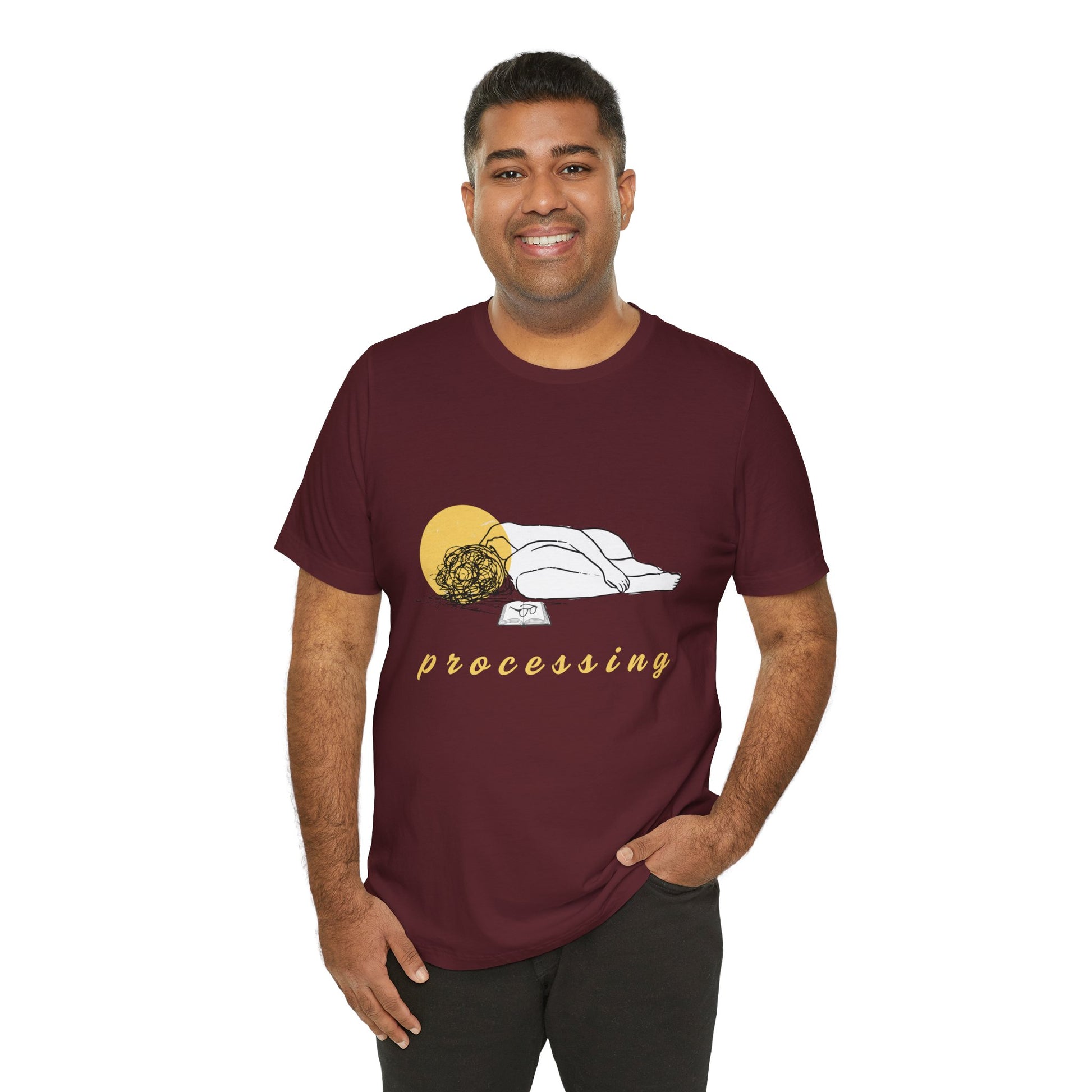 Man wearing a maroon t-shirt with person laying in a heap next to a book and 'processing' text 