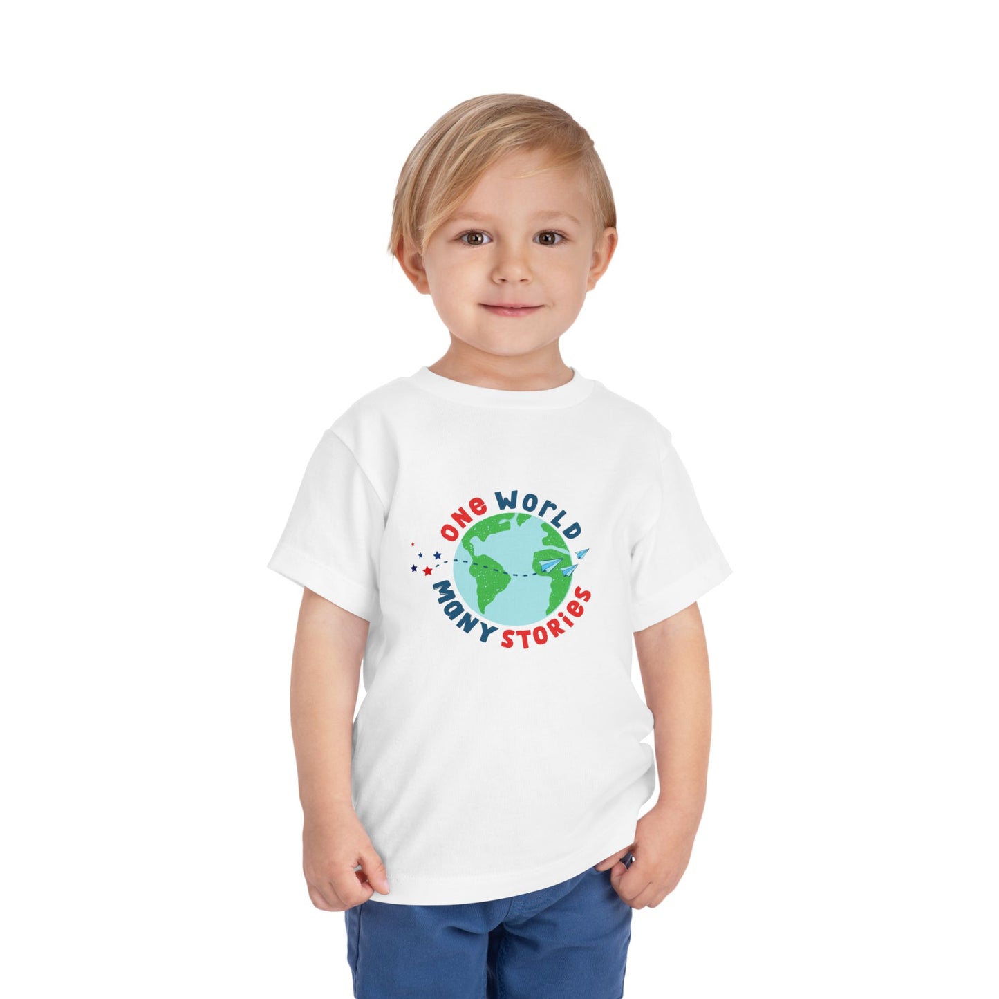 Toddler wearing a white t-shirt with a graphic of the Earth and 'One World, Many Stories' text 