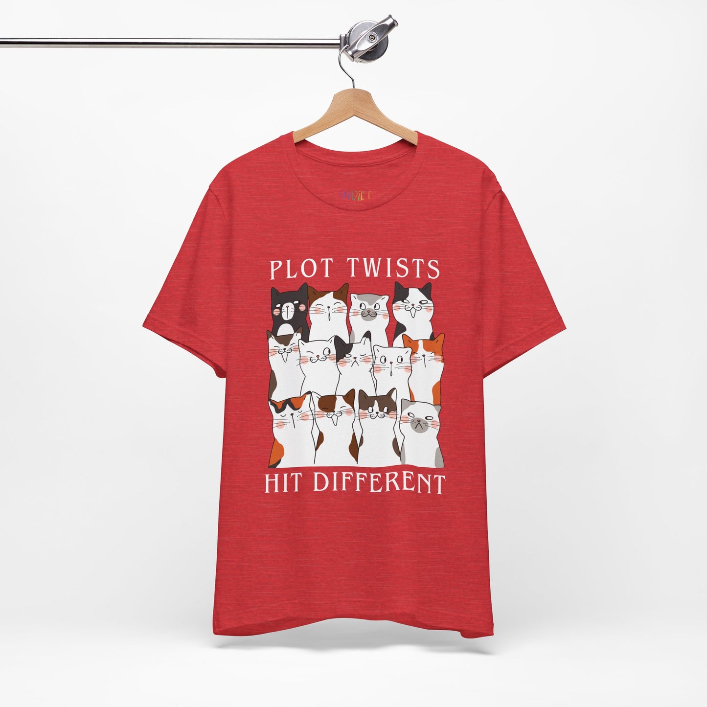Red t-shirt with rows of cats making different faces and text 'Plot Twists Hit Different' 