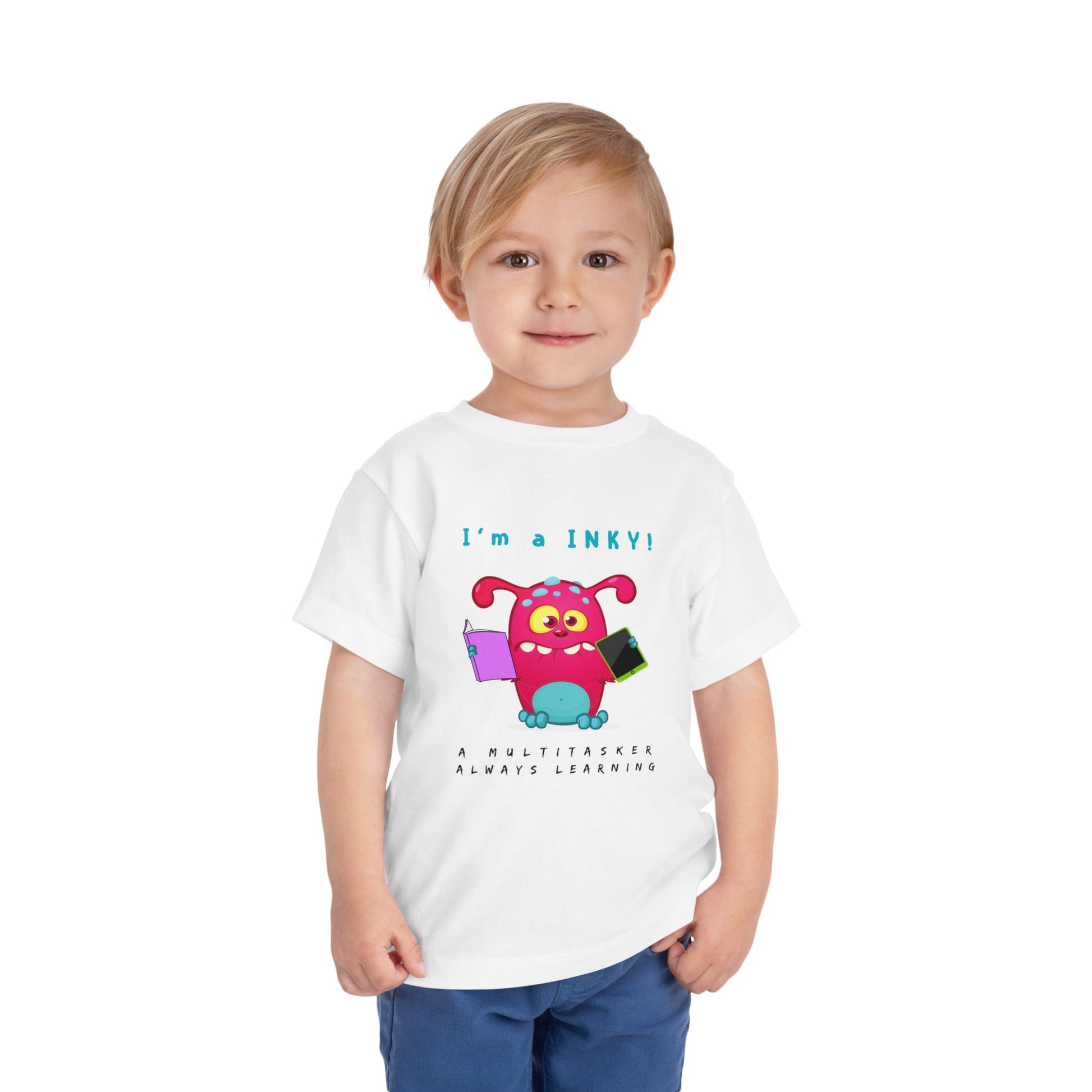 Child wearing a white toddler personality t-shirt with a colorful cartoon monster holding a book and i-pad while proudly proclaiming 'I'm A Inky!' Sub-text "A Multitasker, Always Learning' on a white background