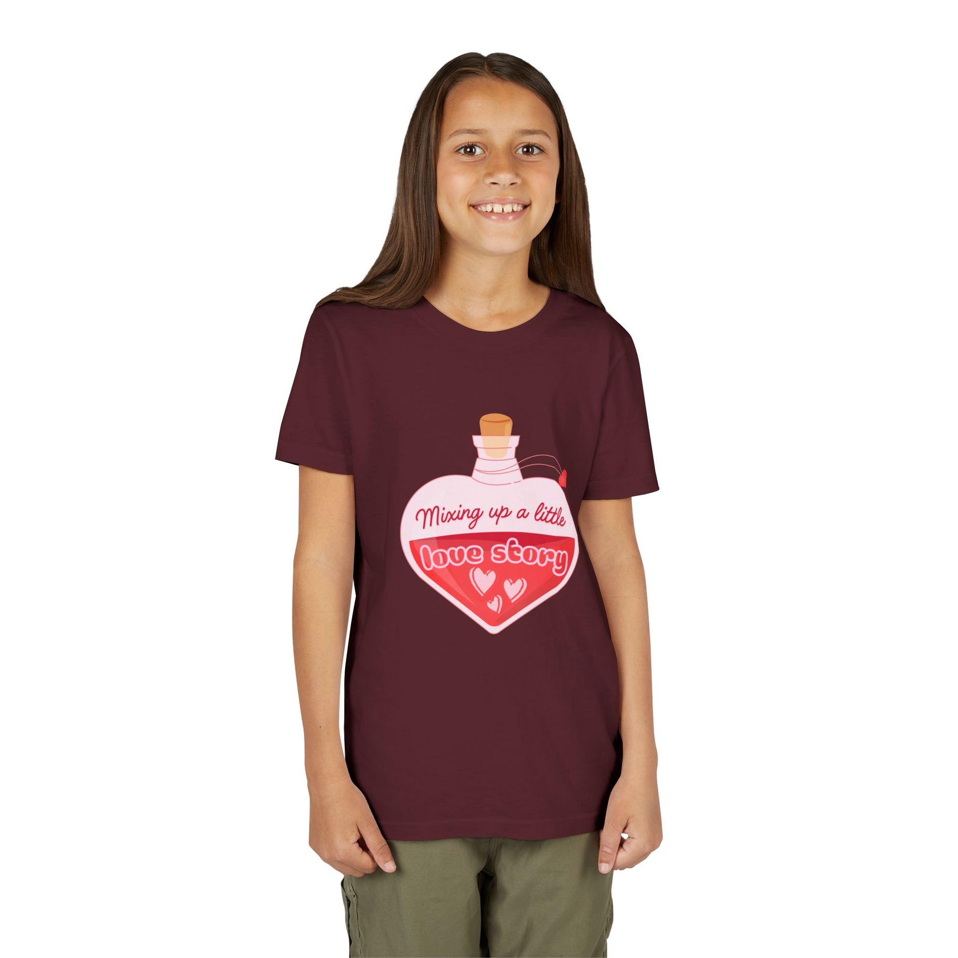 Girl wearing a maroon t-shirt with a heart-shaped potion bottle and text 'Mixing Up A Little Love Story' 