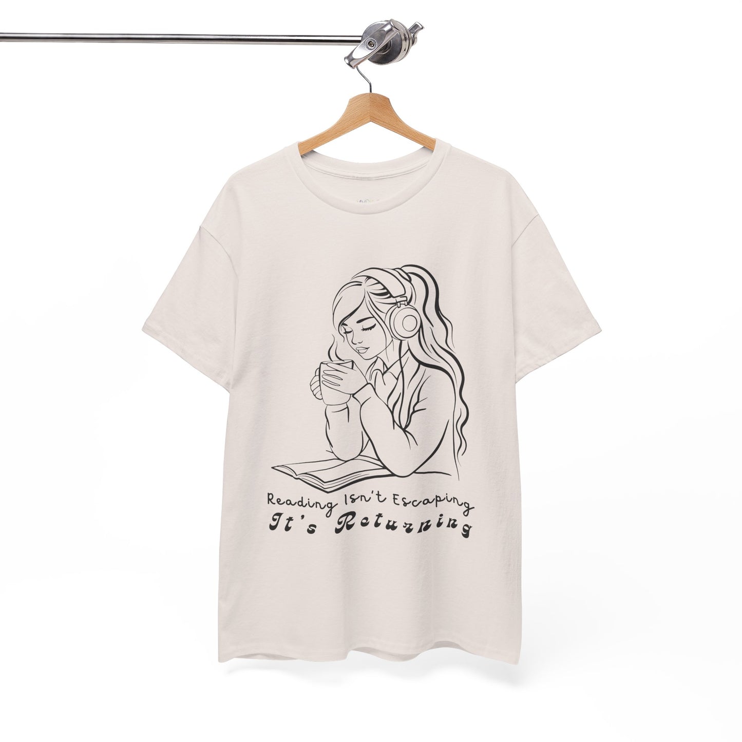 Beige t-shirt with a woman wearing headphones, cupping a hot beverage and reading a book, text 'Reading Isn't Escaping, It's Returning'