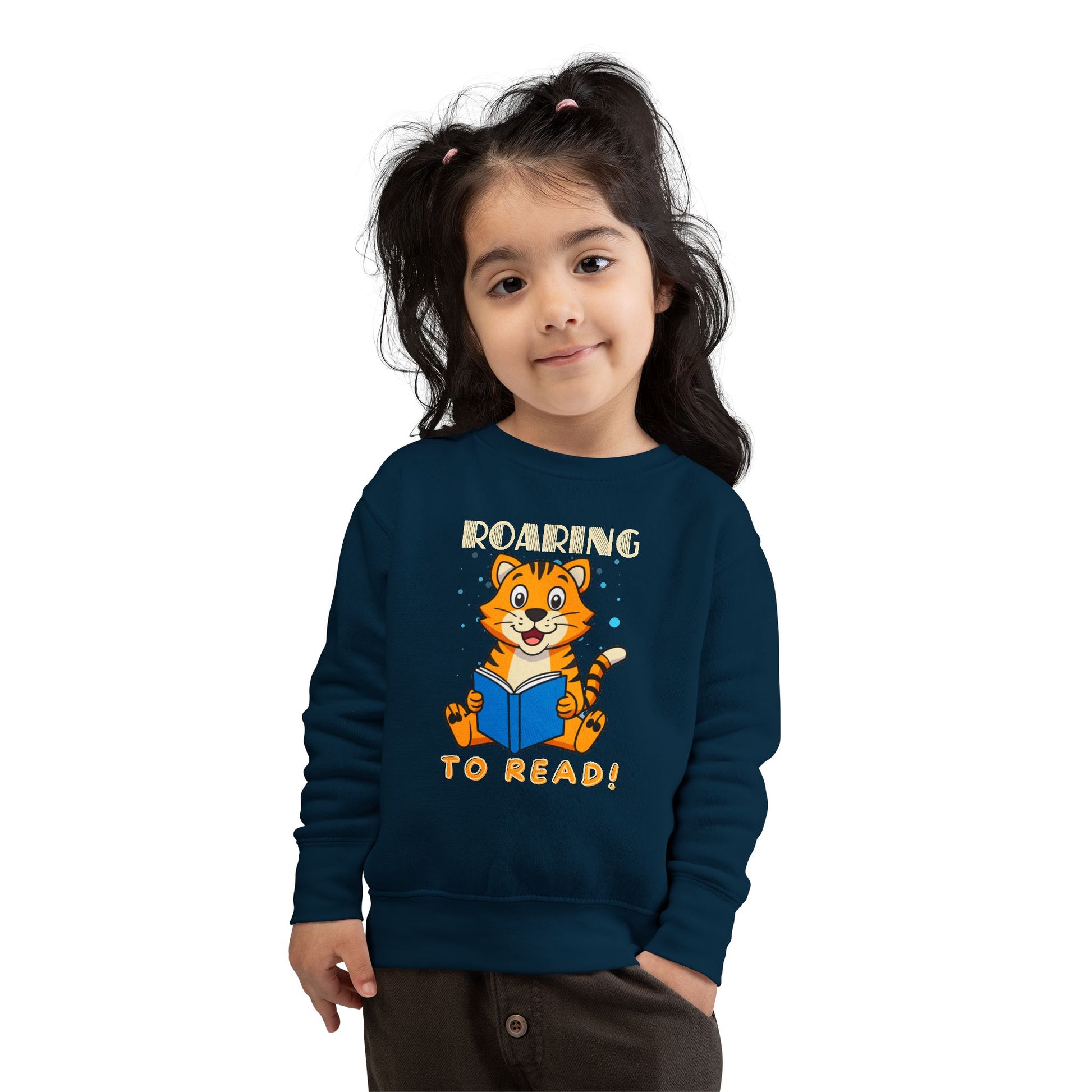 Girl wearing a navy blue toddler sweatshirt with a tiger reading a book graphic and 'Roaring to Read!' text 
