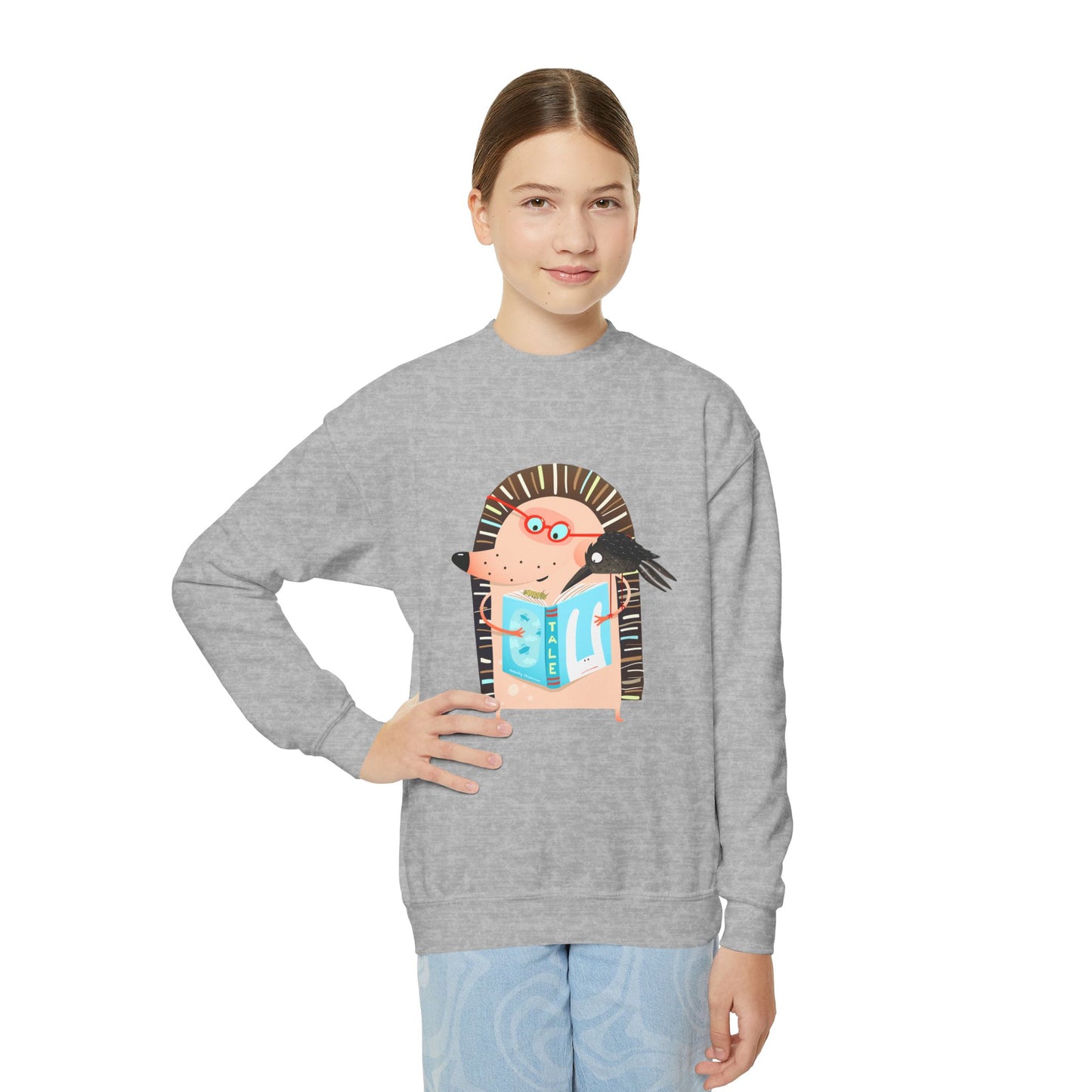 Girl wearing a gray sweatshirt with a cartoon character reading a book with a crow