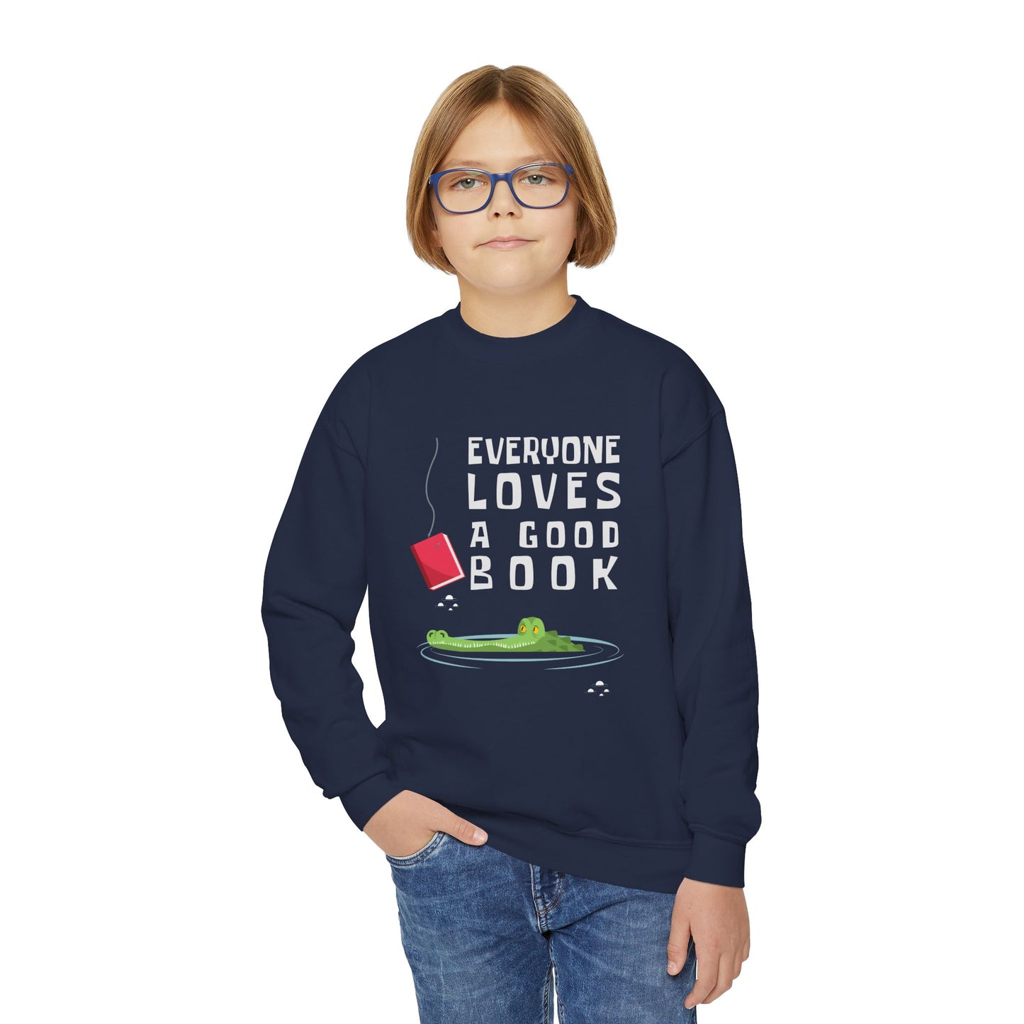 Boy wearing a navy blue sweatshirt with a of an alligator looking at a book on a hook and text 'everyone loves a good book'