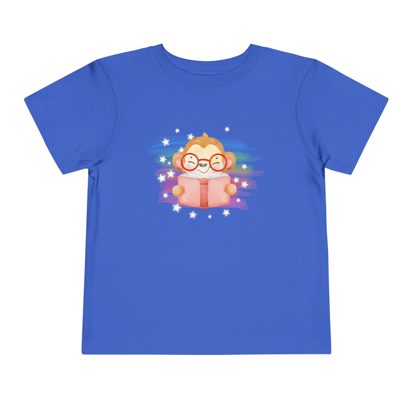 Blue t-shirt with a cartoon monkey reading a book, lit up by rainbow watercolor rainbow and stars