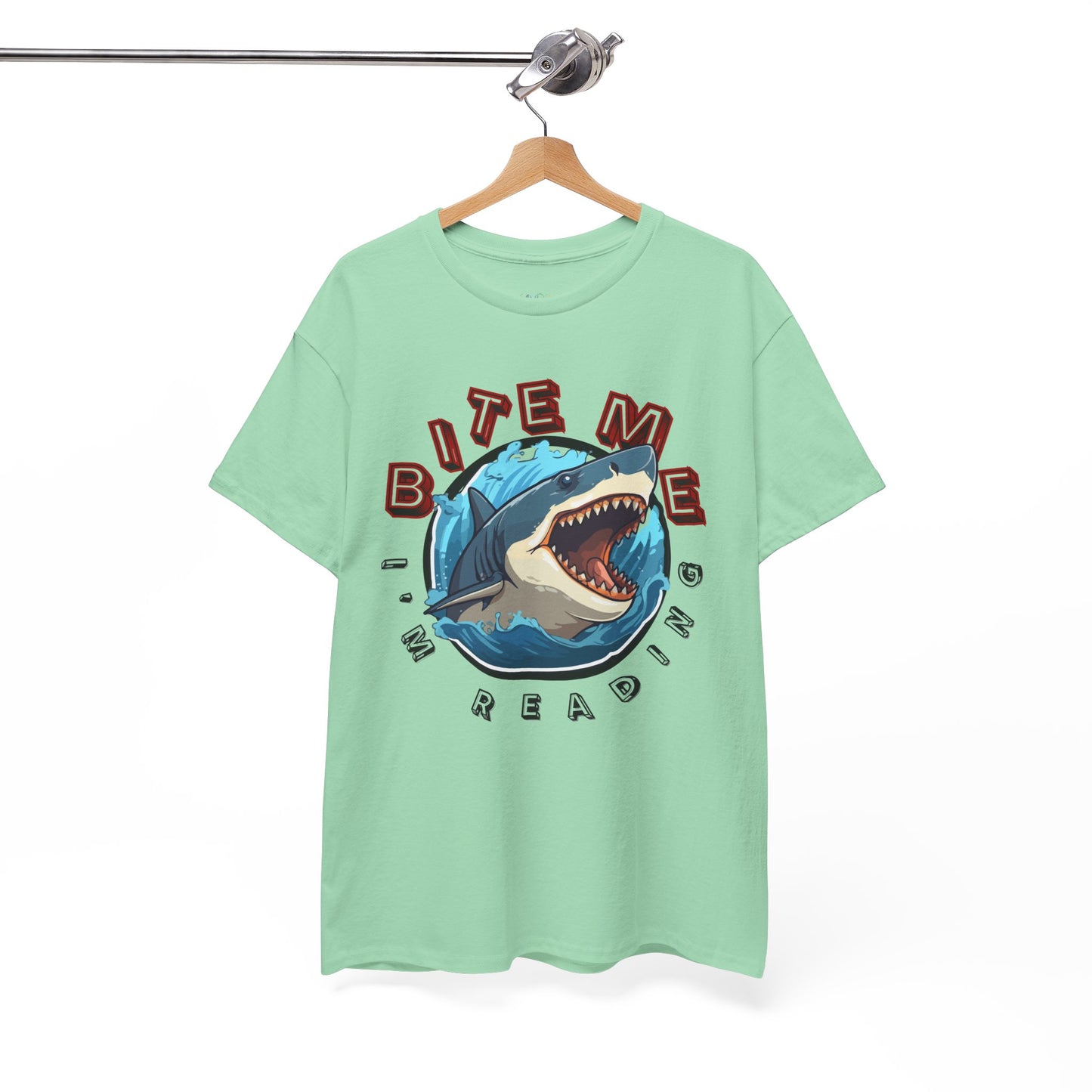 Light green t-shirt with a shark graphic bursting out of the center and text 'Bite Me I'm Reading' 