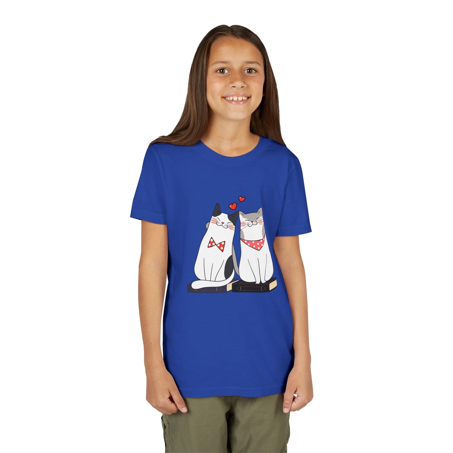Girl wearing a blue t-shirt with two cats snuggled up on books