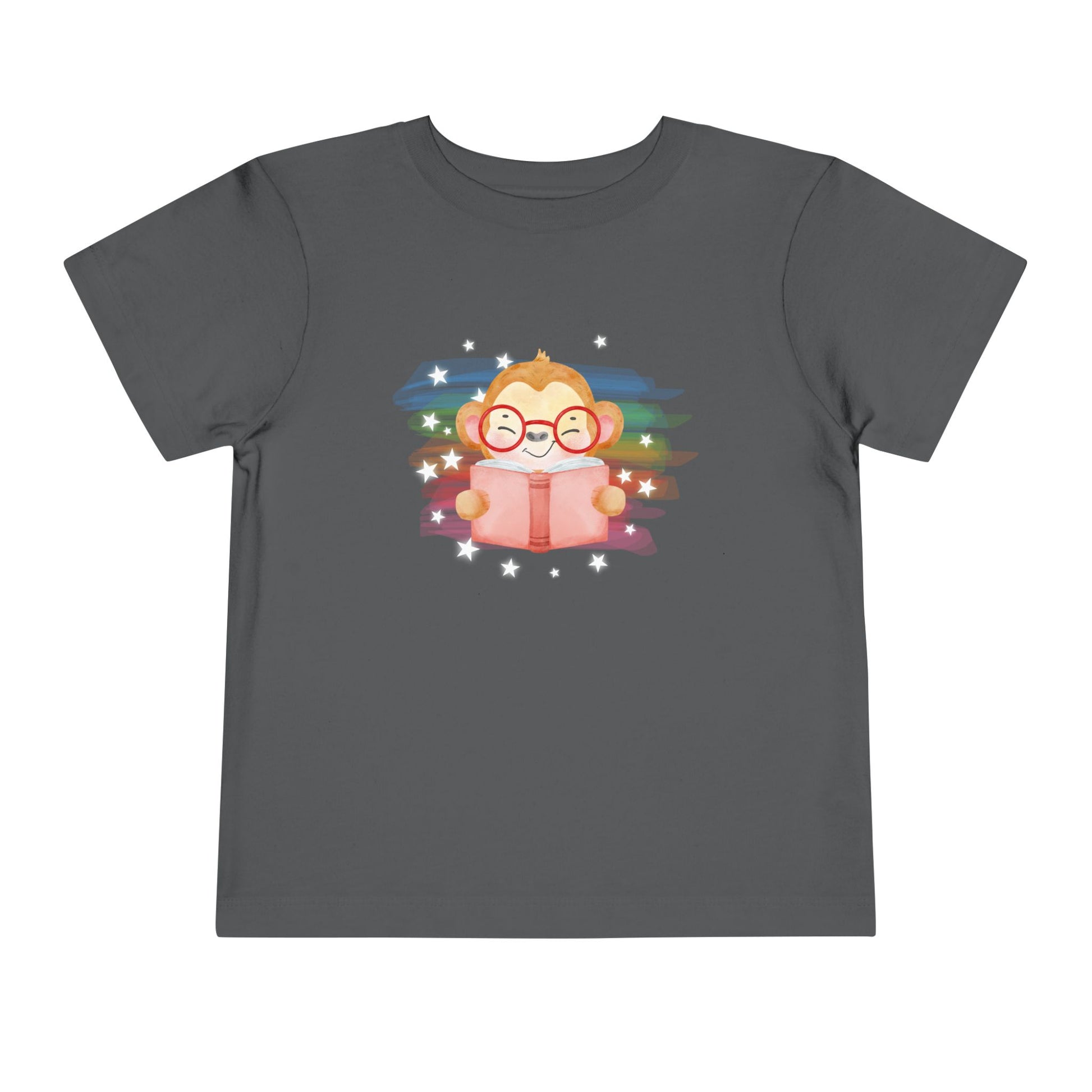 Gray t-shirt with a cartoon monkey reading a book, lit up by rainbow watercolor rainbow and stars