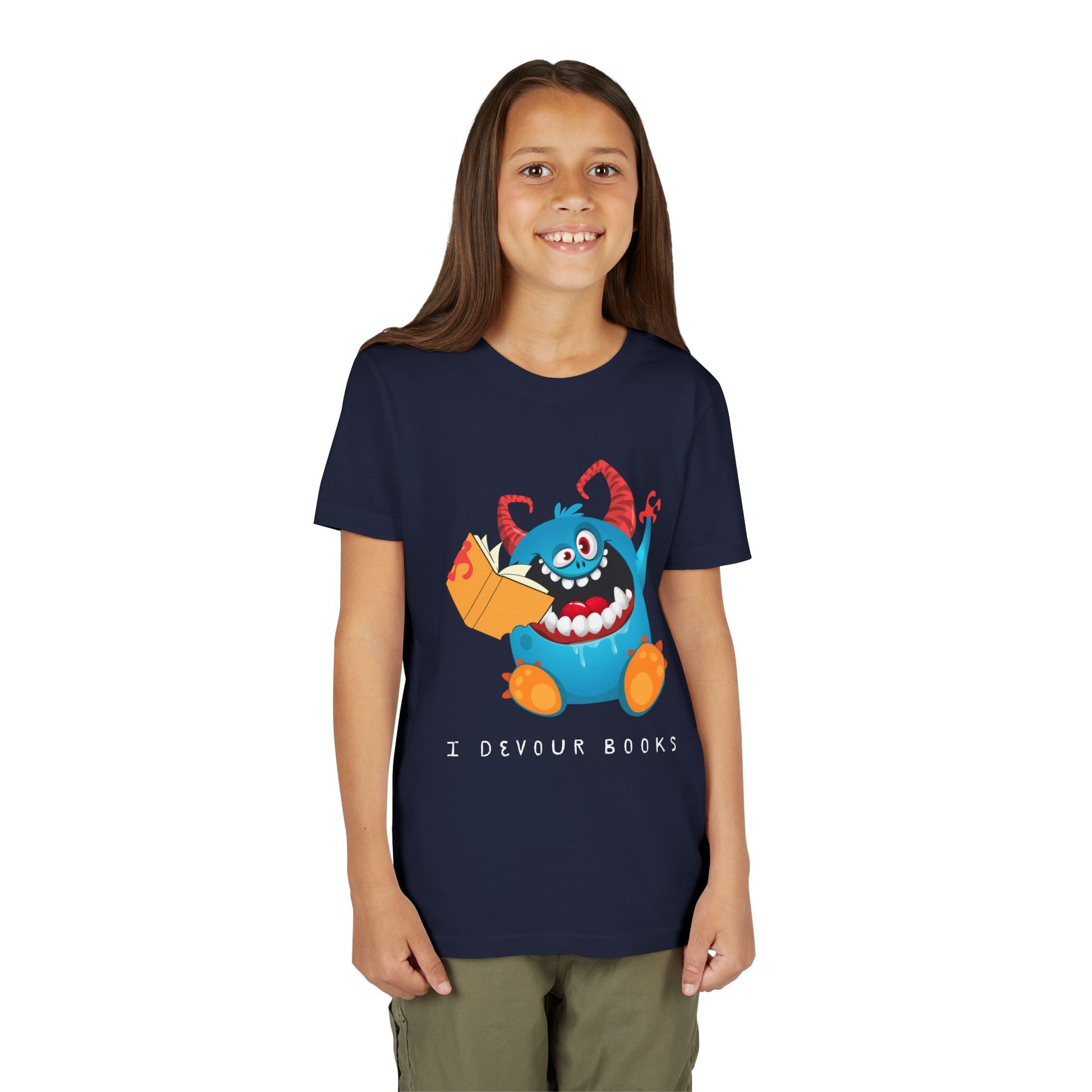 Girl wearing a navy blue t-shirt with a wide mouthed, book chomping cartoon monster and text 'I DEVOUR BOOKS' 