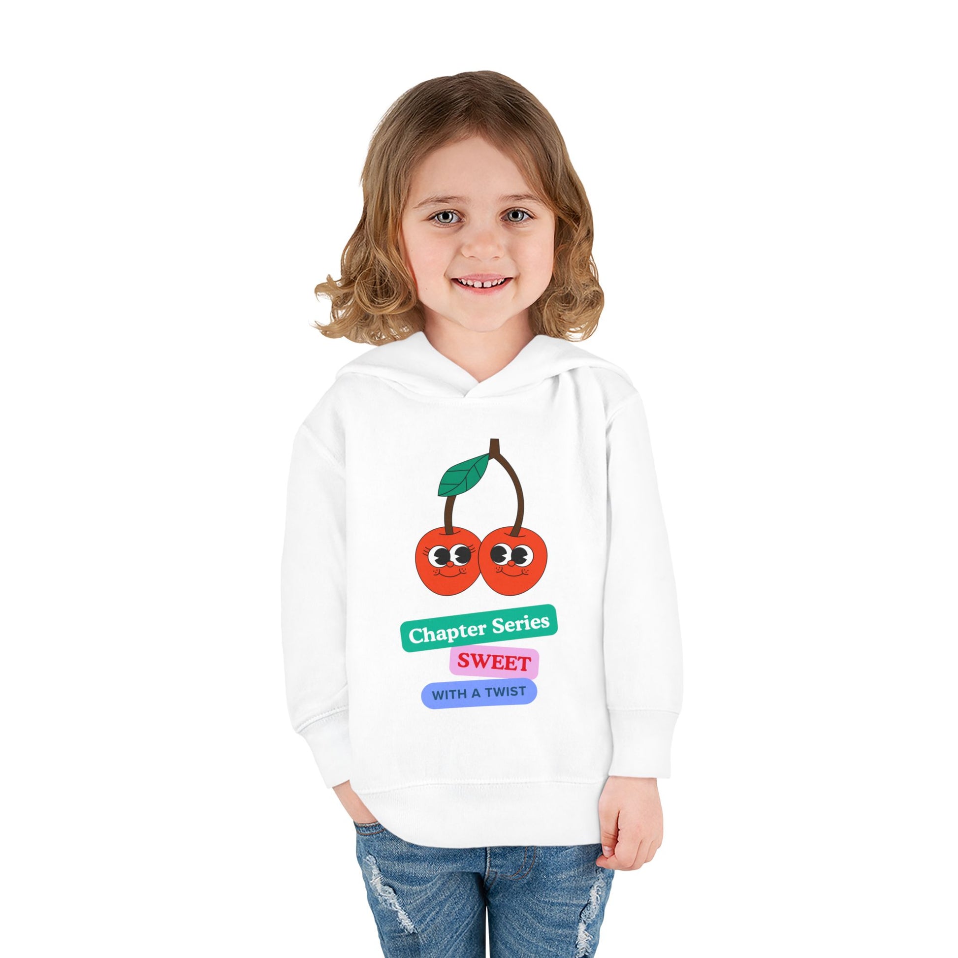 Girl wearing a white hoodie with to smiling cherries and colorful block text 'Chapter Series Sweet With A Twist'