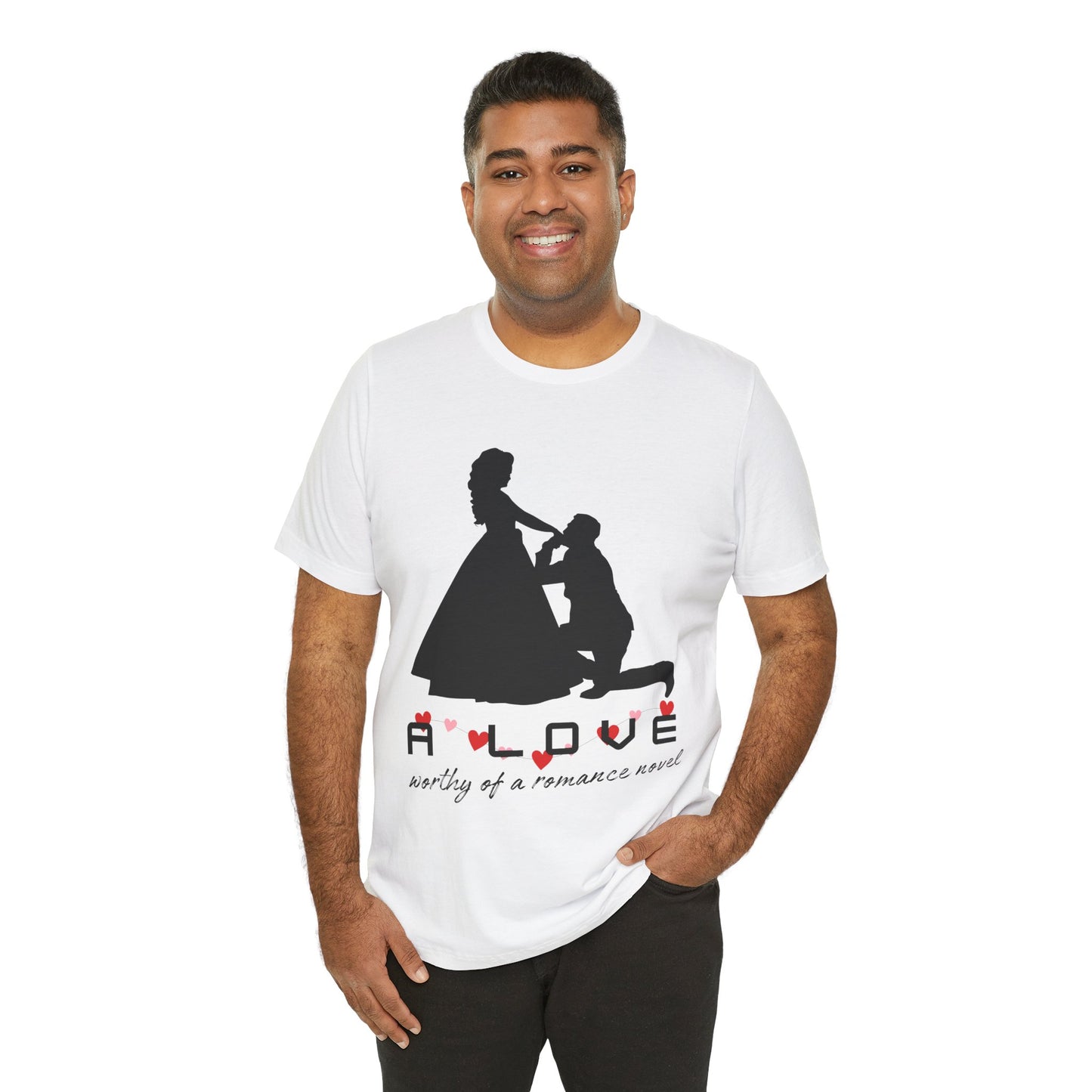 A man wearing a white t-shirt with black graphic if a man kneeling in front of a woman in a gown and text 'A LOVE worthy of a romance novel'