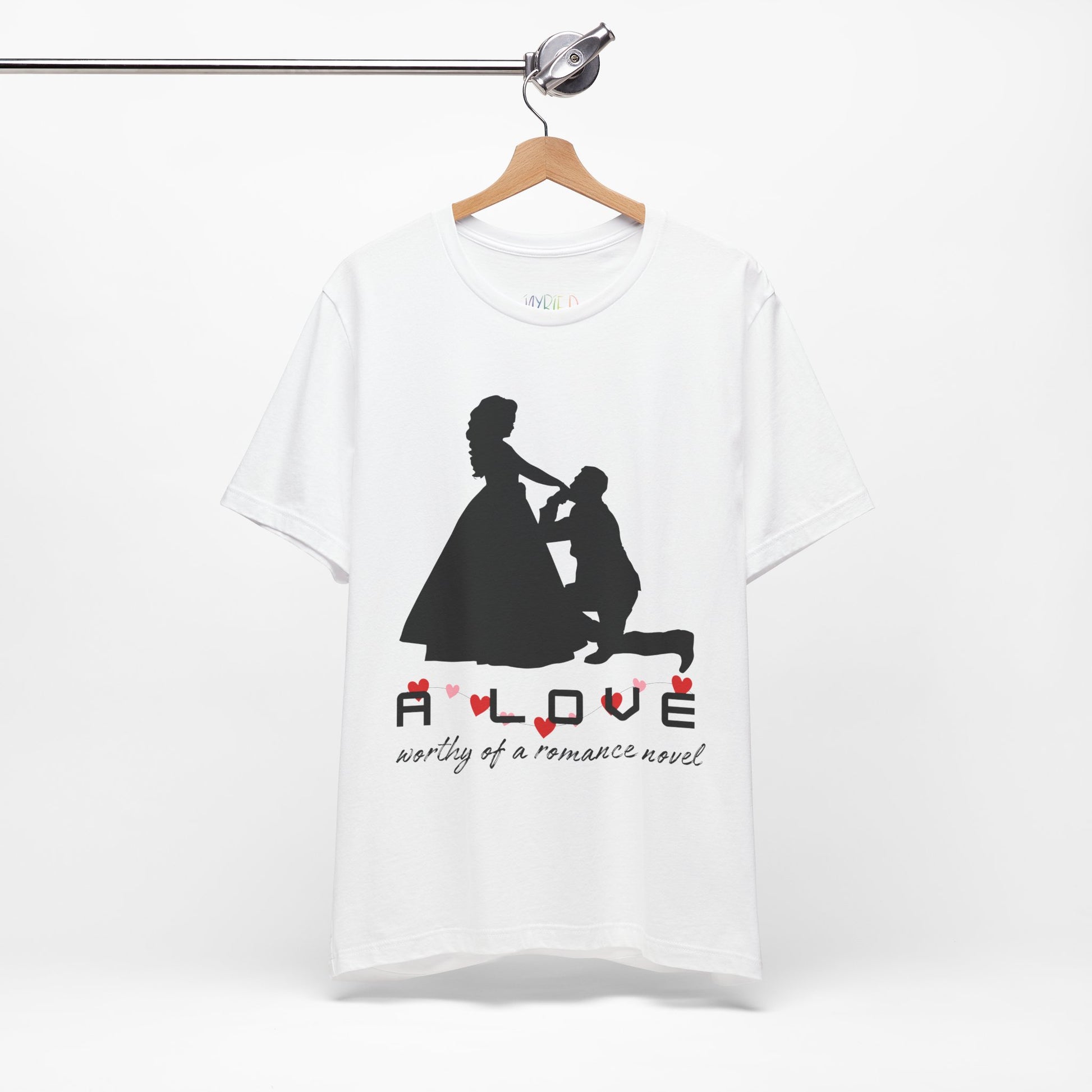 White t-shirt with black graphic if a man kneeling in front of a woman in a gown and text 'A LOVE worthy of a romance novel'