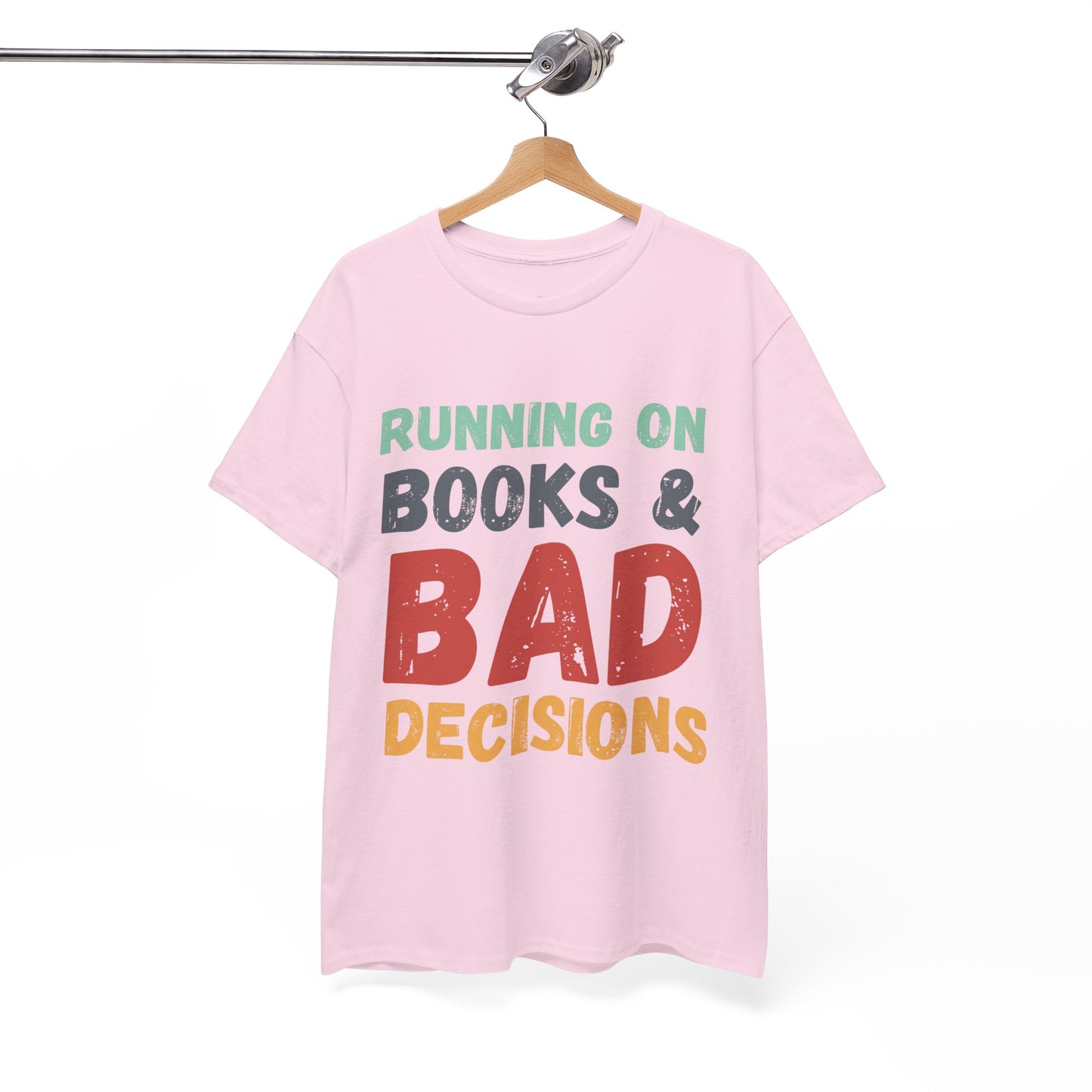 Pink t-shirt with colorful retro text 'Running on Books & Bad Decisions' 