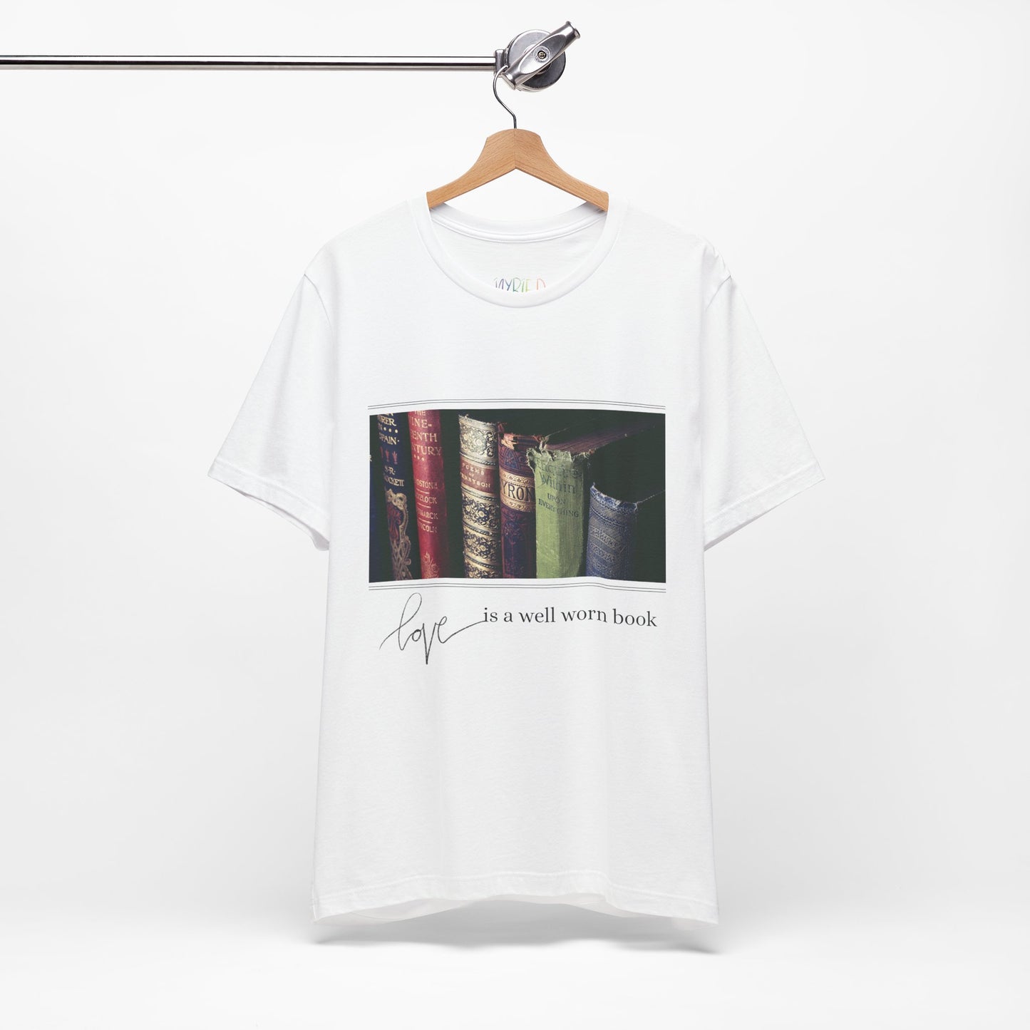 White t-shirt with a row of old books and text 'Love Is A Well Worn Book'