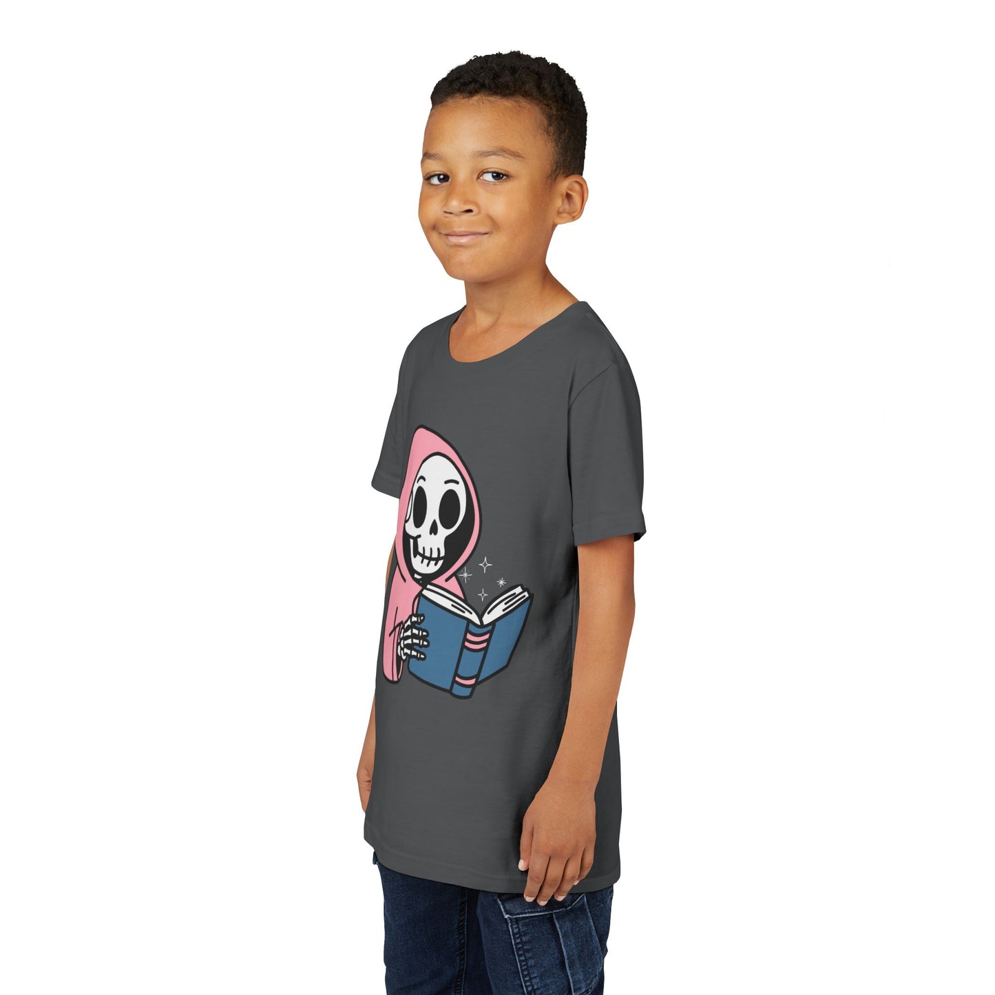 Boy wearing a gray t-shirt with a cartoon skeleton wearing a pink hoodie and reading a book