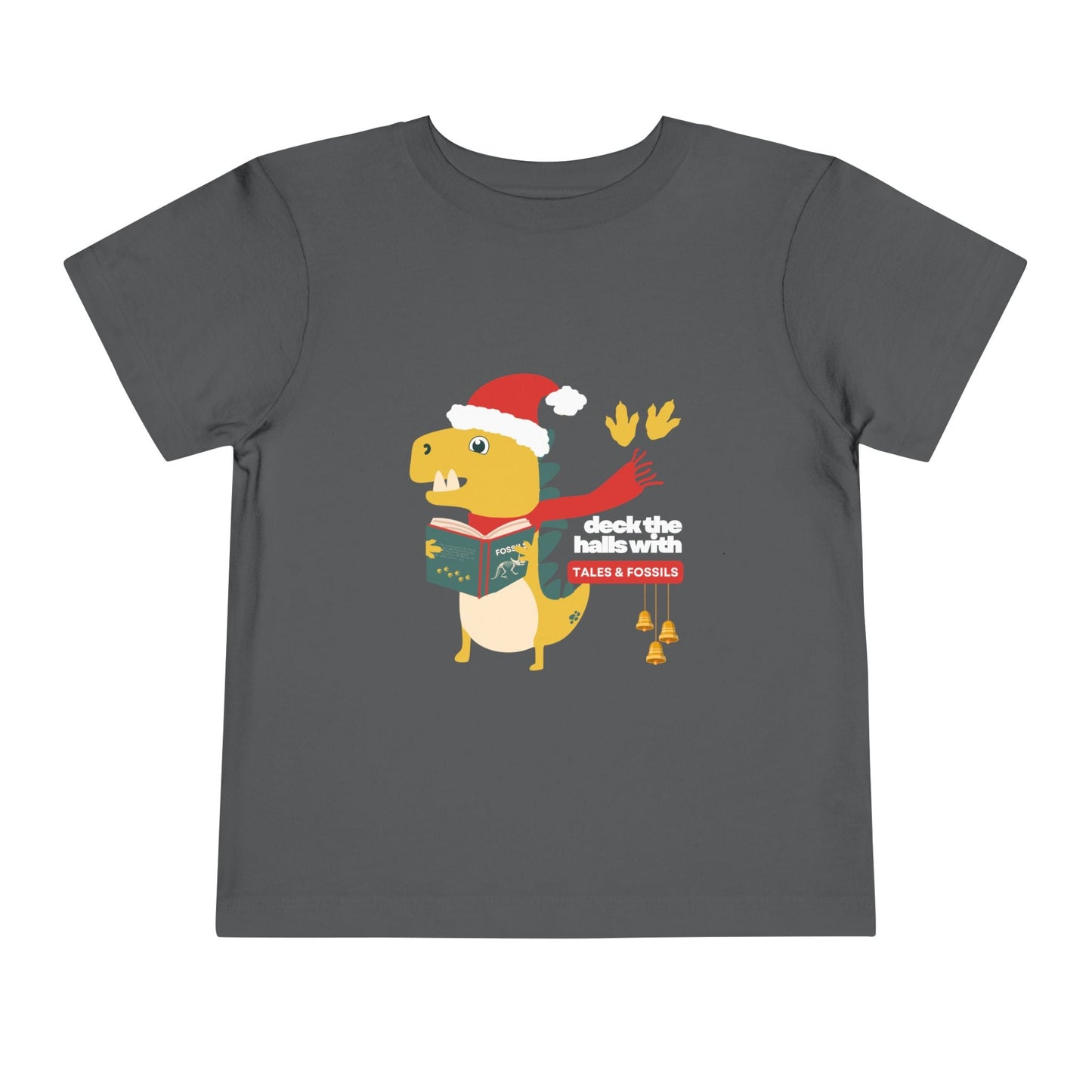Gray toddler t-shirt with a Christmas-themed dinosaur graphic reading or singing from a book, and text 'deck the halls with tales & fossils' on a white background