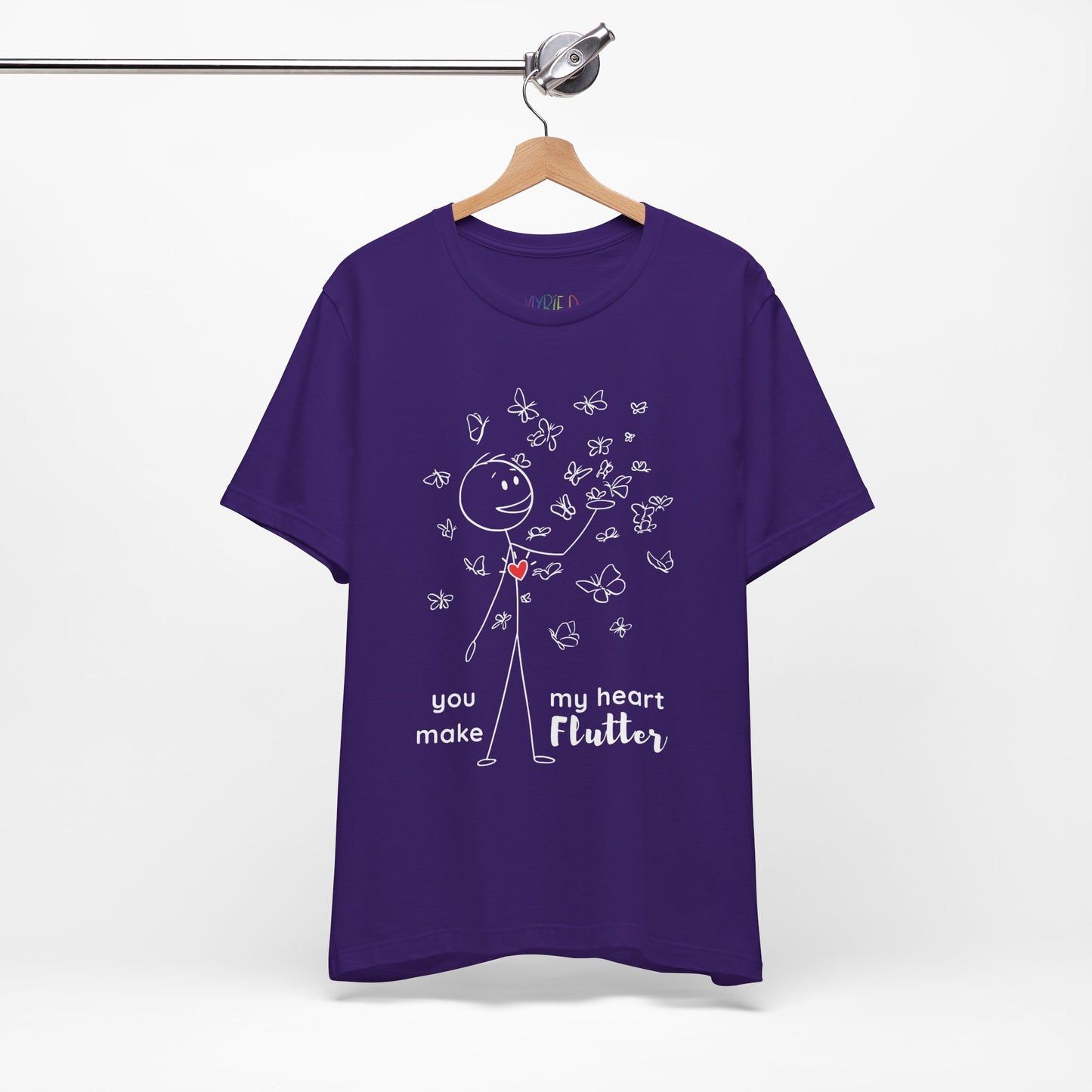 Purple t-shirt with a stick figure surrounded by butterflies and a red heart beating on his chest, text 'You Make My Heart Flutter'