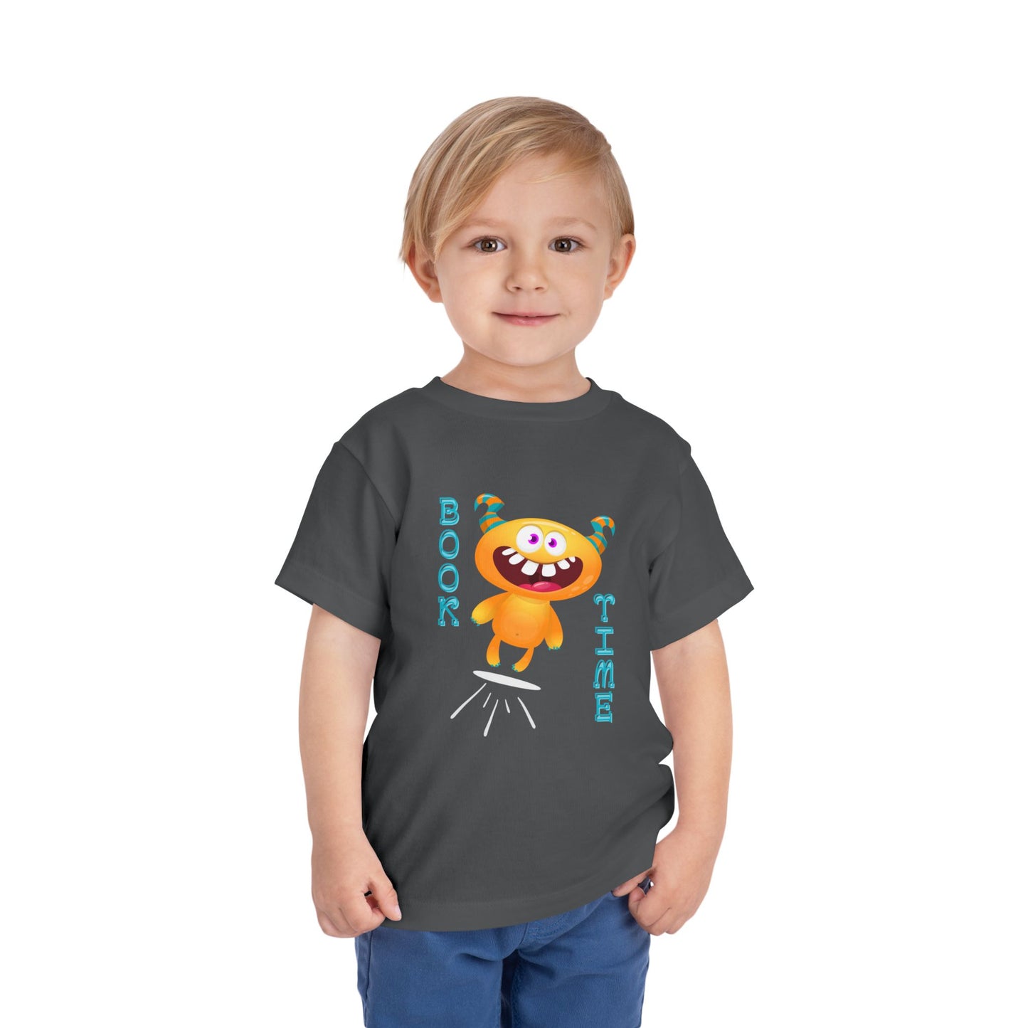 Child wearing a gray toddler t-shirt with a jumping cartoon monster design and text 'BOOK TIME'