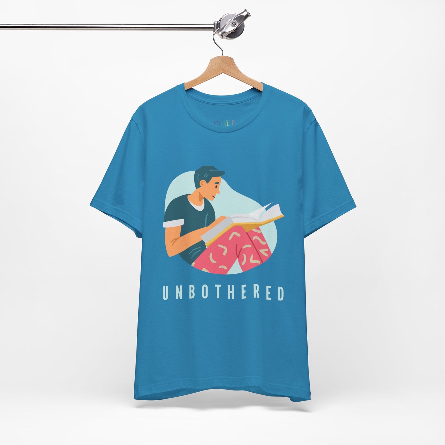 Turquoise t-shirt with a man reading a book and 'UNBOTHERED' text 