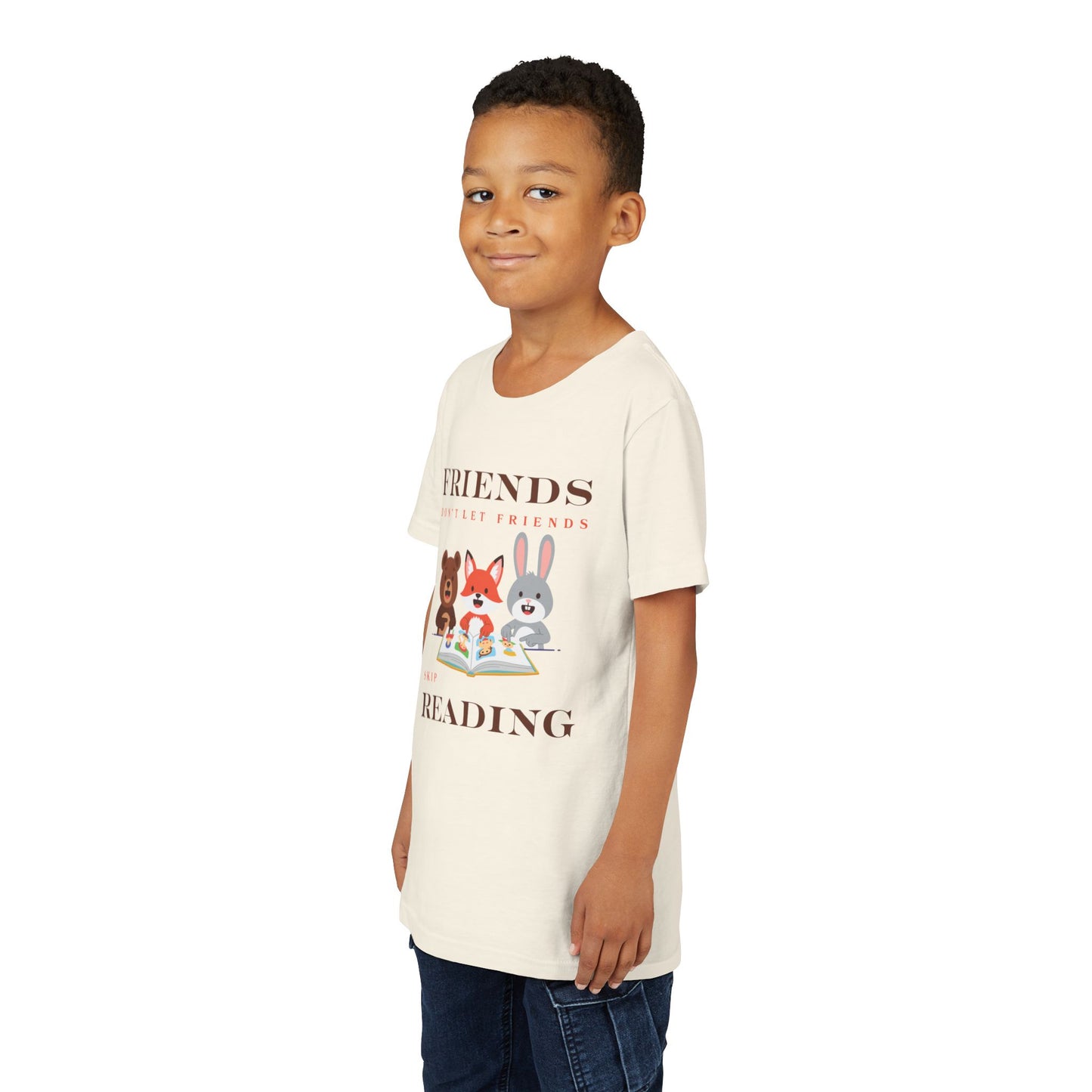 Boy wearing a beige t-shirt with cartoon animals reading a book and text 'Friends don't let friends skip reading' 