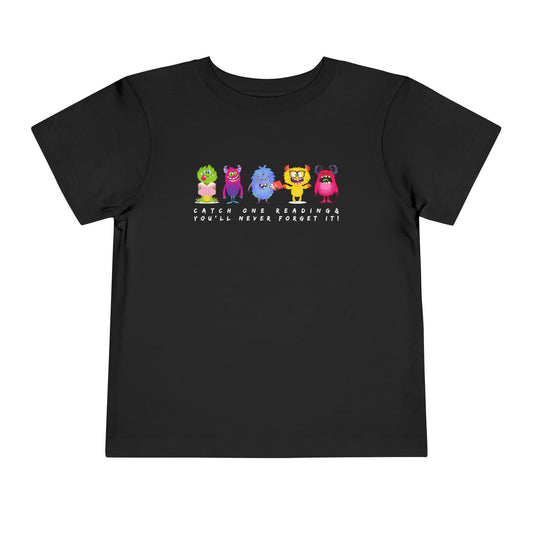 Black toddler t-shirt with colorful monsters all lined up in a row and text 'Catch One Reading & You'll Never Forget It!' 