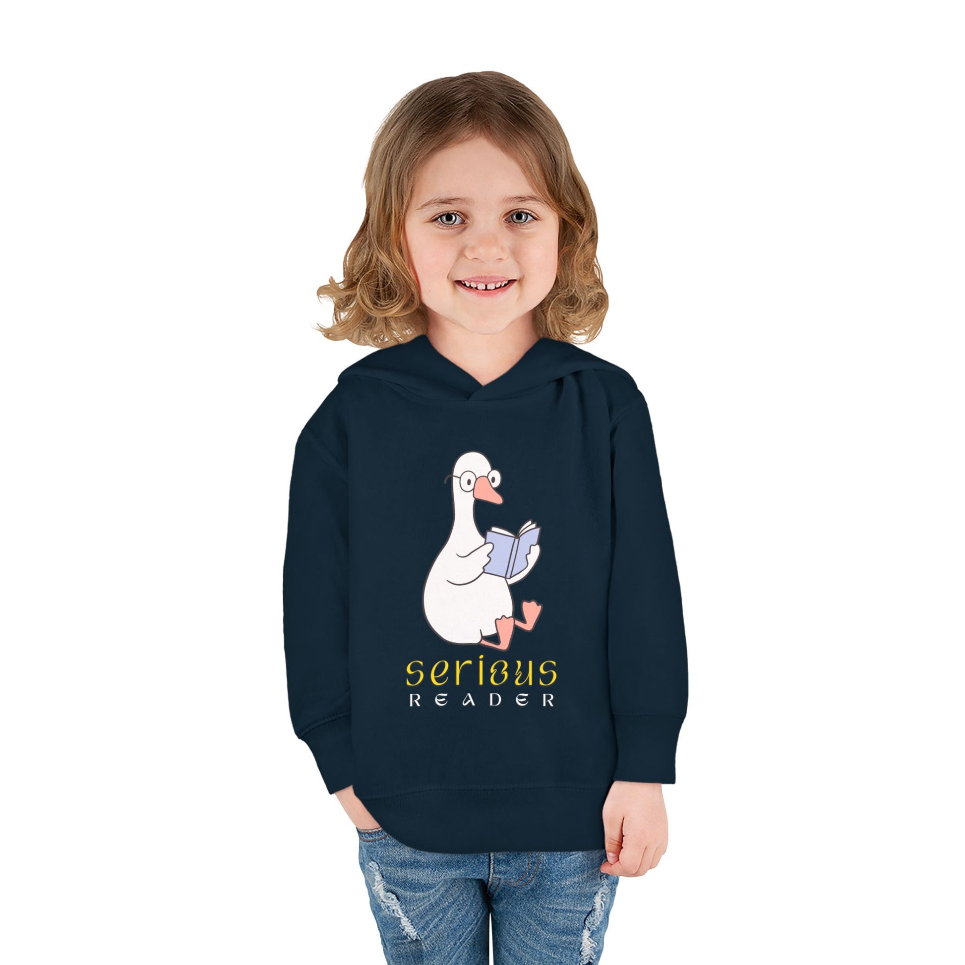 Girl wearing a navy blue toddler hoodie with a cartoon goose reading a book and 'Serious Reader' text 