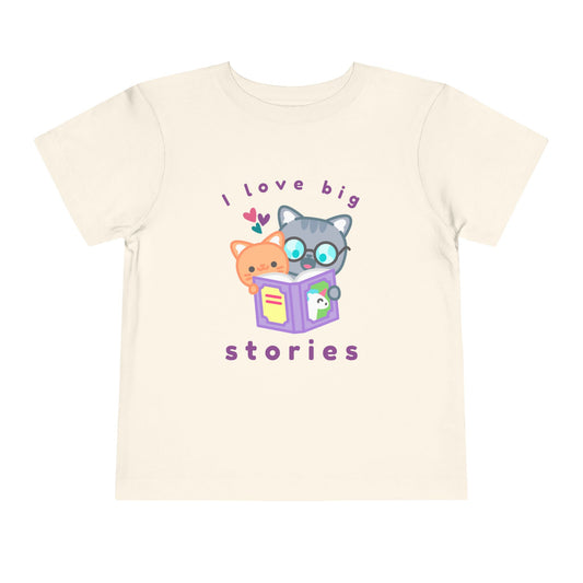 Beige toddler t-shirt with cartoon cats reading a unicorn book and 'I love big stories' text 