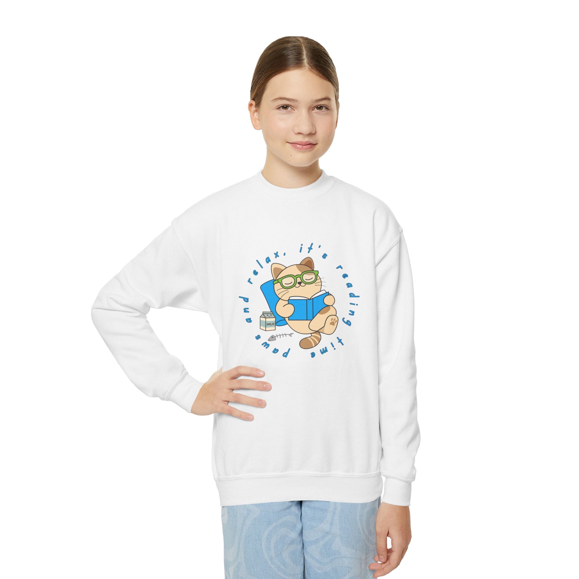 Girl wearing a white sweatshirt with a cartoon cat reading a book, circled by text 'paws and relax, it's reading time'