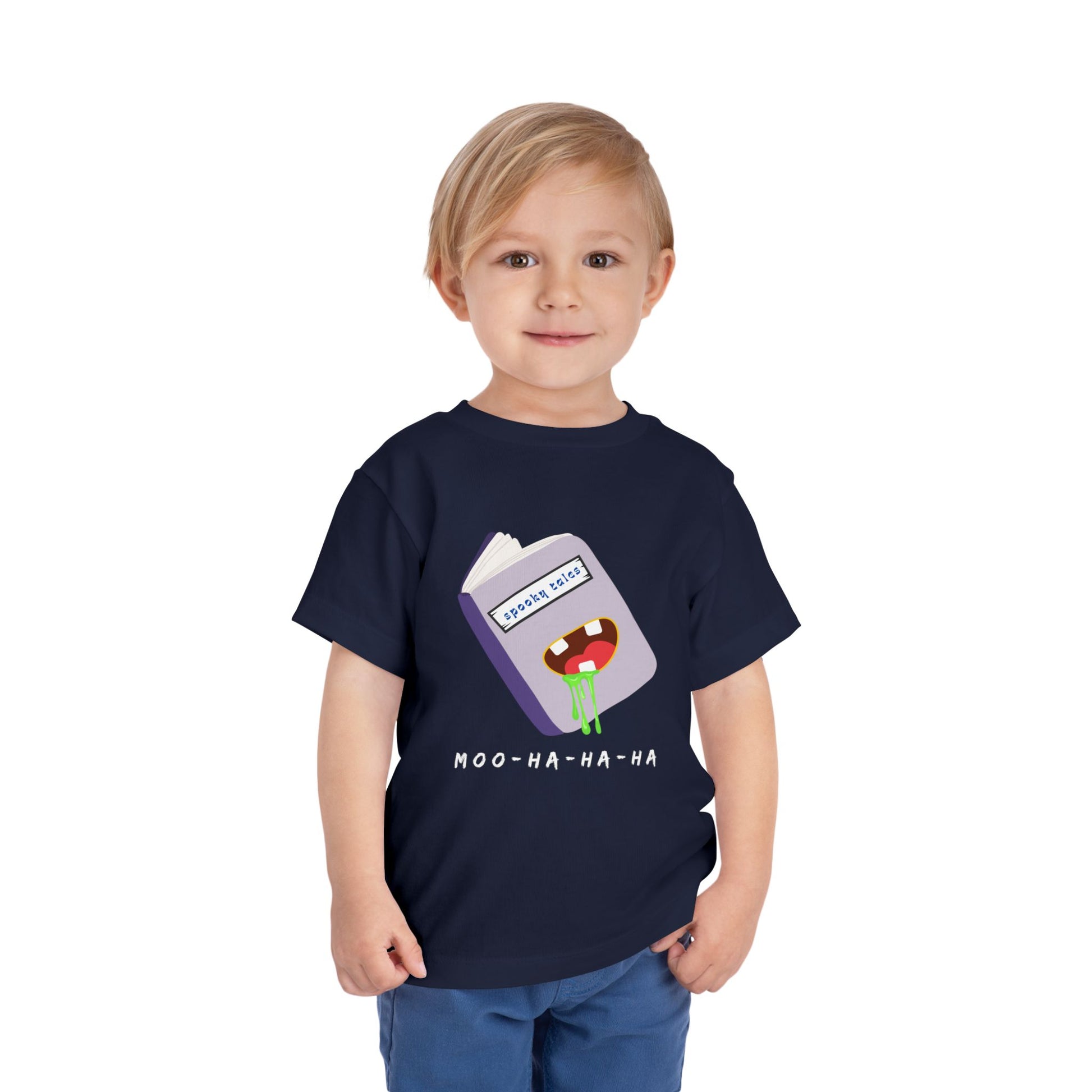Child wearing a navy blue toddler 'Moo-Ha-Ha-Ha' spooky tales t-shirt on a white back ground