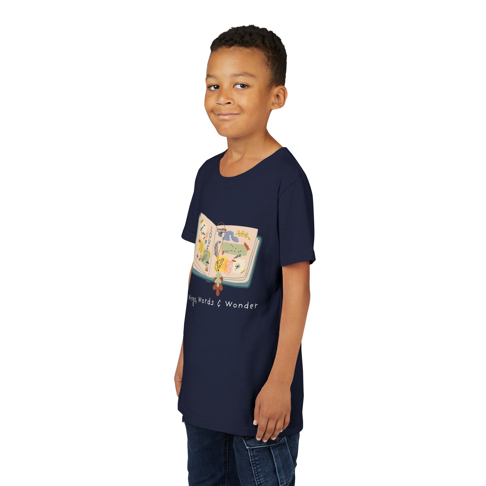 Boy wearing a navy blue t-shirt with an open scrap book  and text 'Wings, Words & Wonder' 